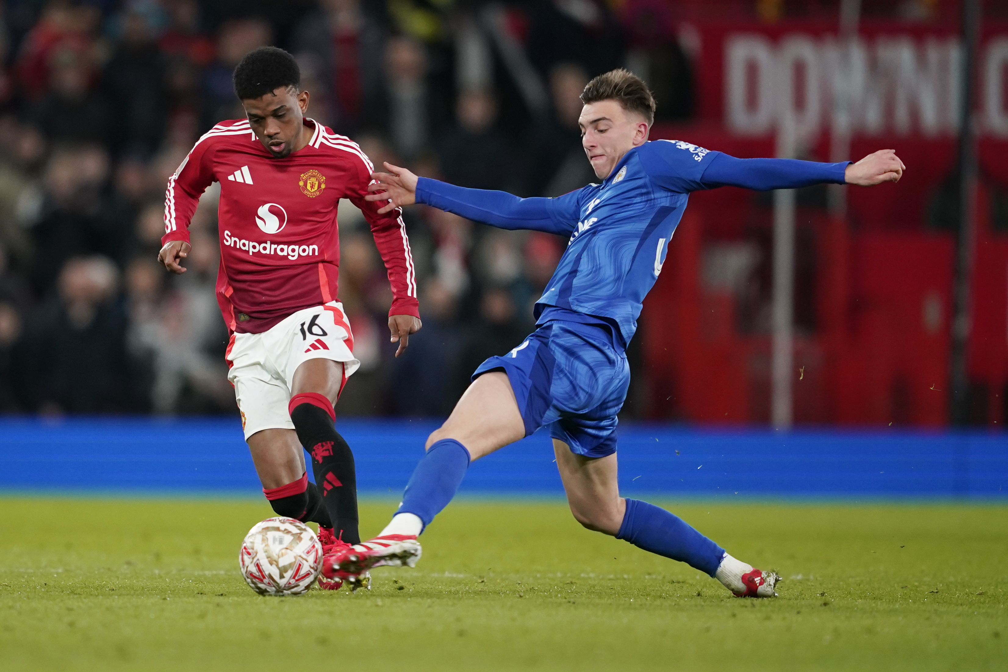 Leicester's Luke Thomas, right, and Manchester United's Amad Diallo challenge for the ball during the English FA Cup fourth round soccer match between Manchester United and Leicester City at the Old Trafford stadium in Manchester, England, Friday, Feb. 7, 2025.