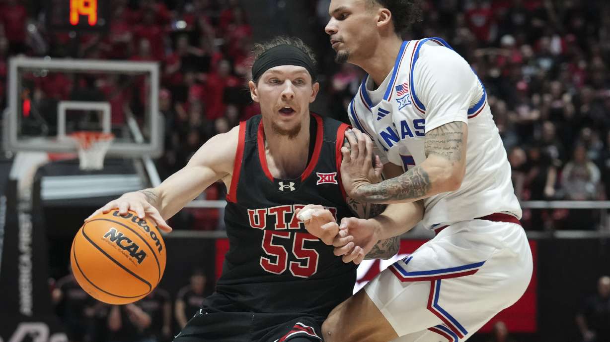 Utah guard Gabe Madsen (55) dribbles around Kansas guard Zeke Mayo (5) during the second half of an NCAA college basketball game, Saturday, Feb. 15, 2025, in Salt Lake City.