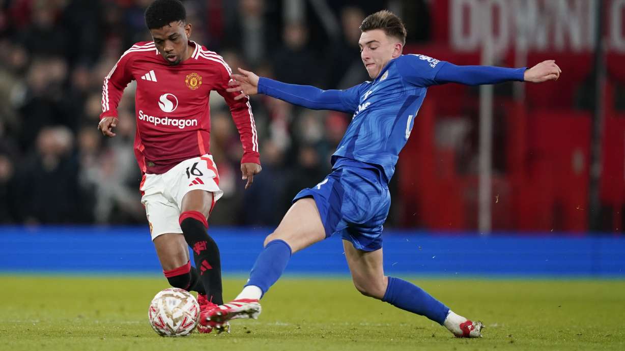 Leicester's Luke Thomas, right, and Manchester United's Amad Diallo challenge for the ball during the English FA Cup fourth round soccer match between Manchester United and Leicester City at the Old Trafford stadium in Manchester, England, Friday, Feb. 7, 2025.