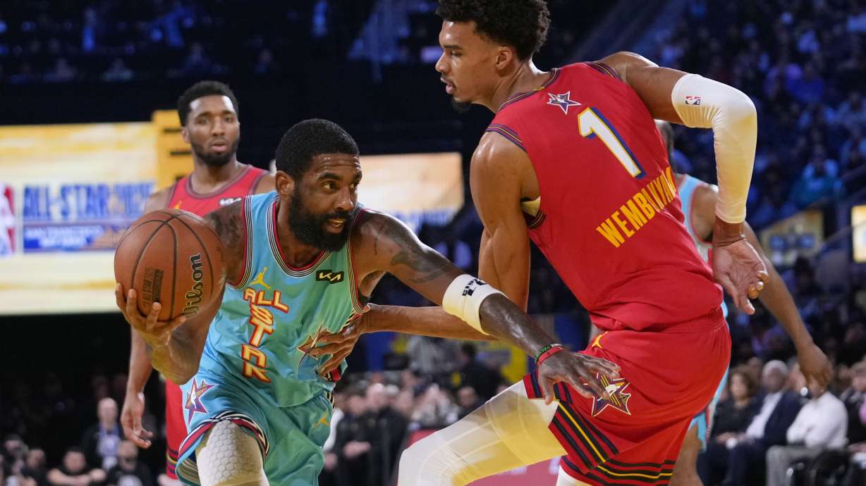 Dallas Mavericks guard Kyrie Irving, left, dribbles past San Antonio Spurs center Victor Wembanyama during the NBA All-Star basketball game Sunday, Feb. 16, 2025, in San Francisco.