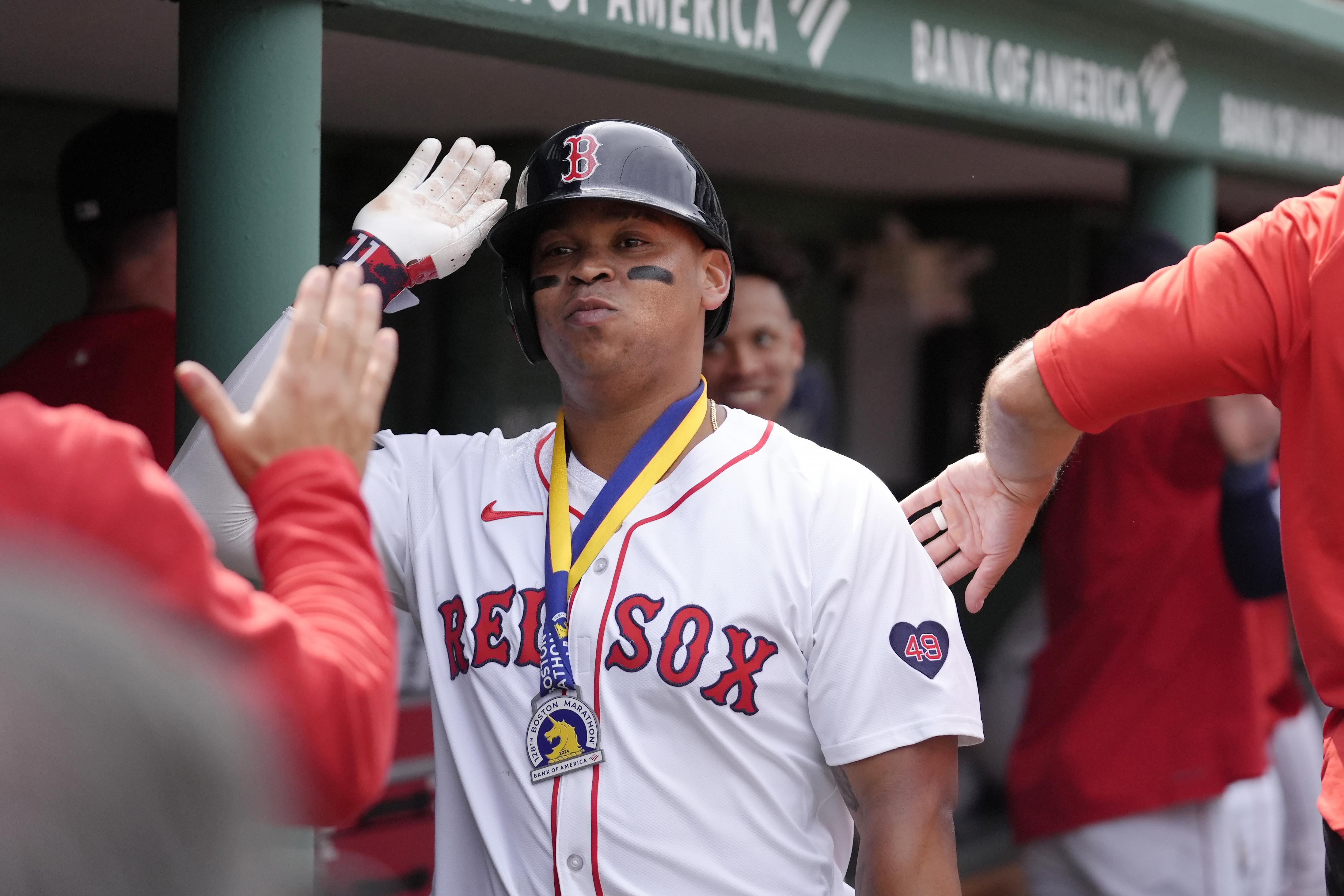 FILE - Boston Red Sox's Rafael Devers celebrates with teammates in the dugout after scoring on his three-run home run the fourth inning of a baseball game against the Arizona Diamondbacks, Aug. 25, 2024, in Boston.