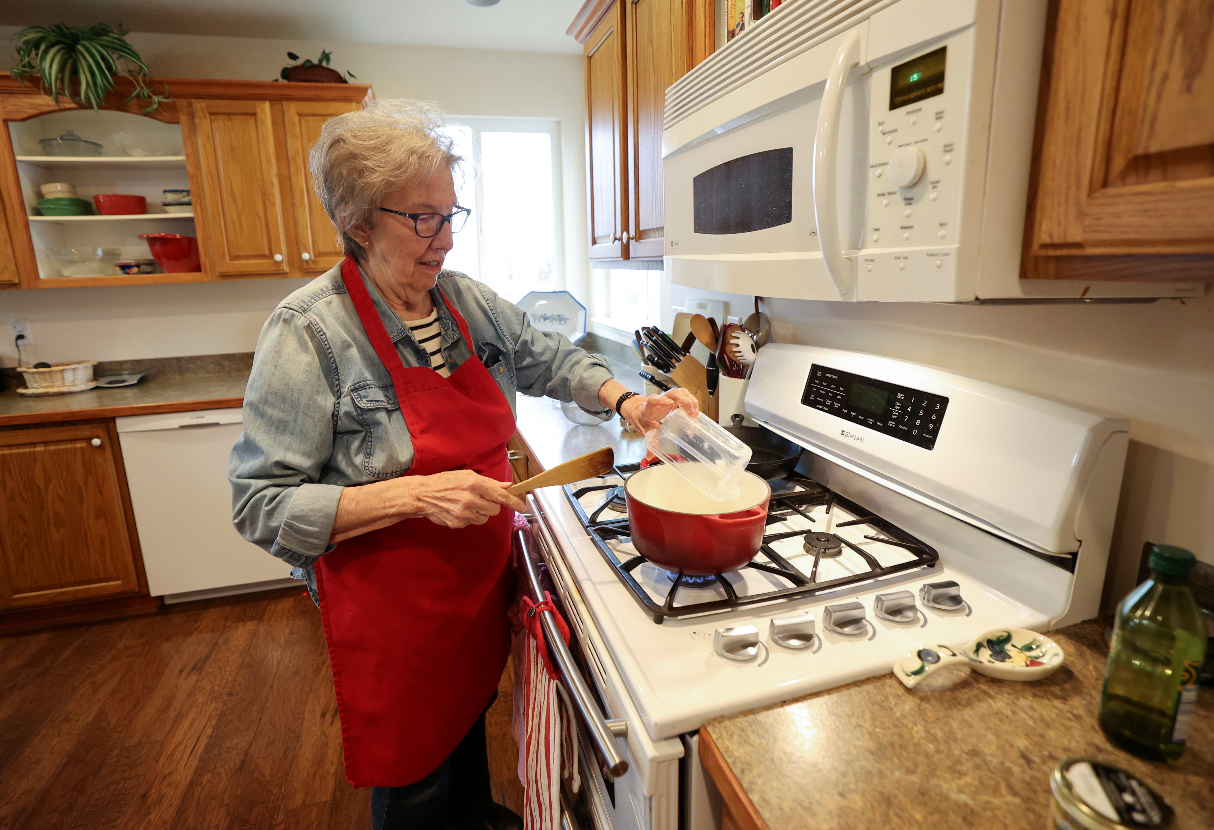 Deanna Buck uses her gas stove to cook lunch at home in Hooper on Feb. 13.