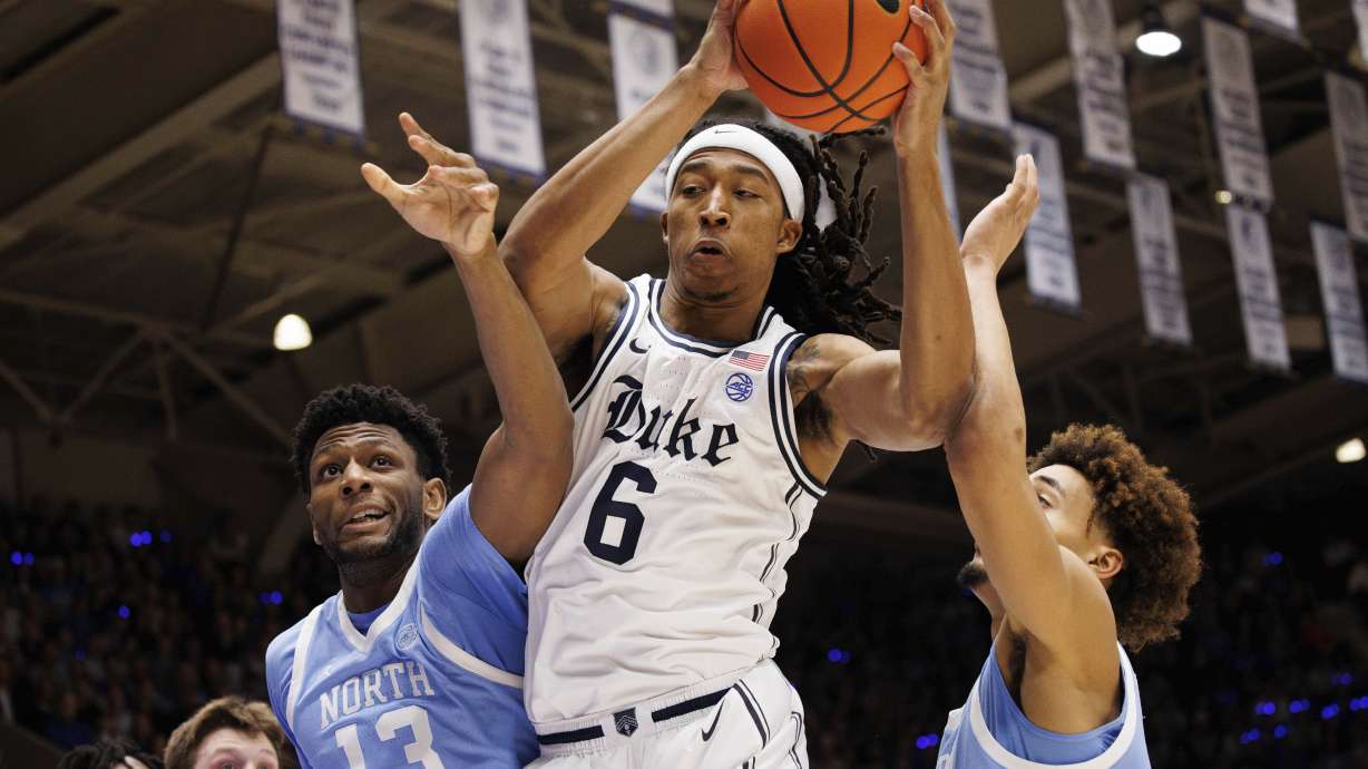 Duke's Maliq Brown (6) grabs a rebound between North Carolina's Jalen Washington (13) and Seth Trimble, right, during the first half of an NCAA college basketball game in Durham, N.C., Saturday, Feb. 1, 2025.