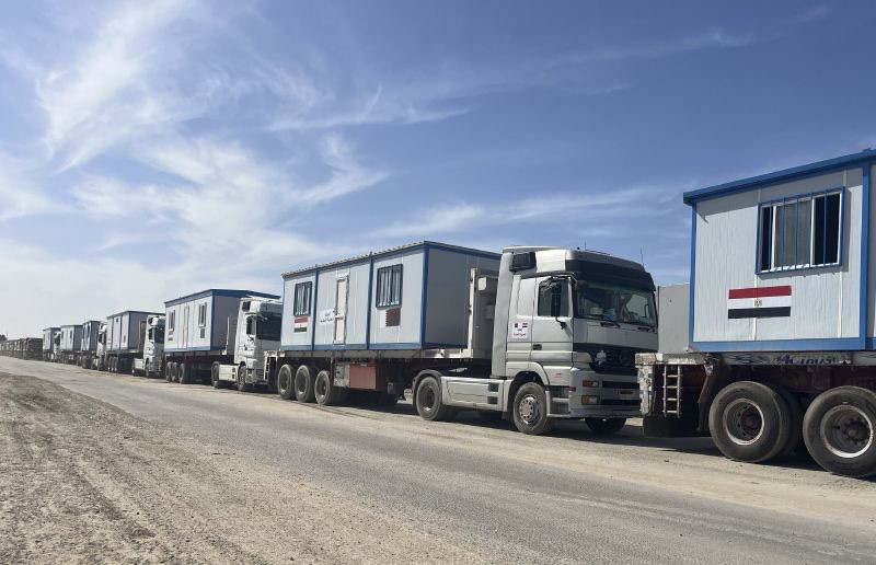 Scores of trucks carrying mobile homes line up on the Egyptian side of the Rafah crossing in preparation for entering Gaza, at the Rafah border crossing, Egypt, Tuesday.