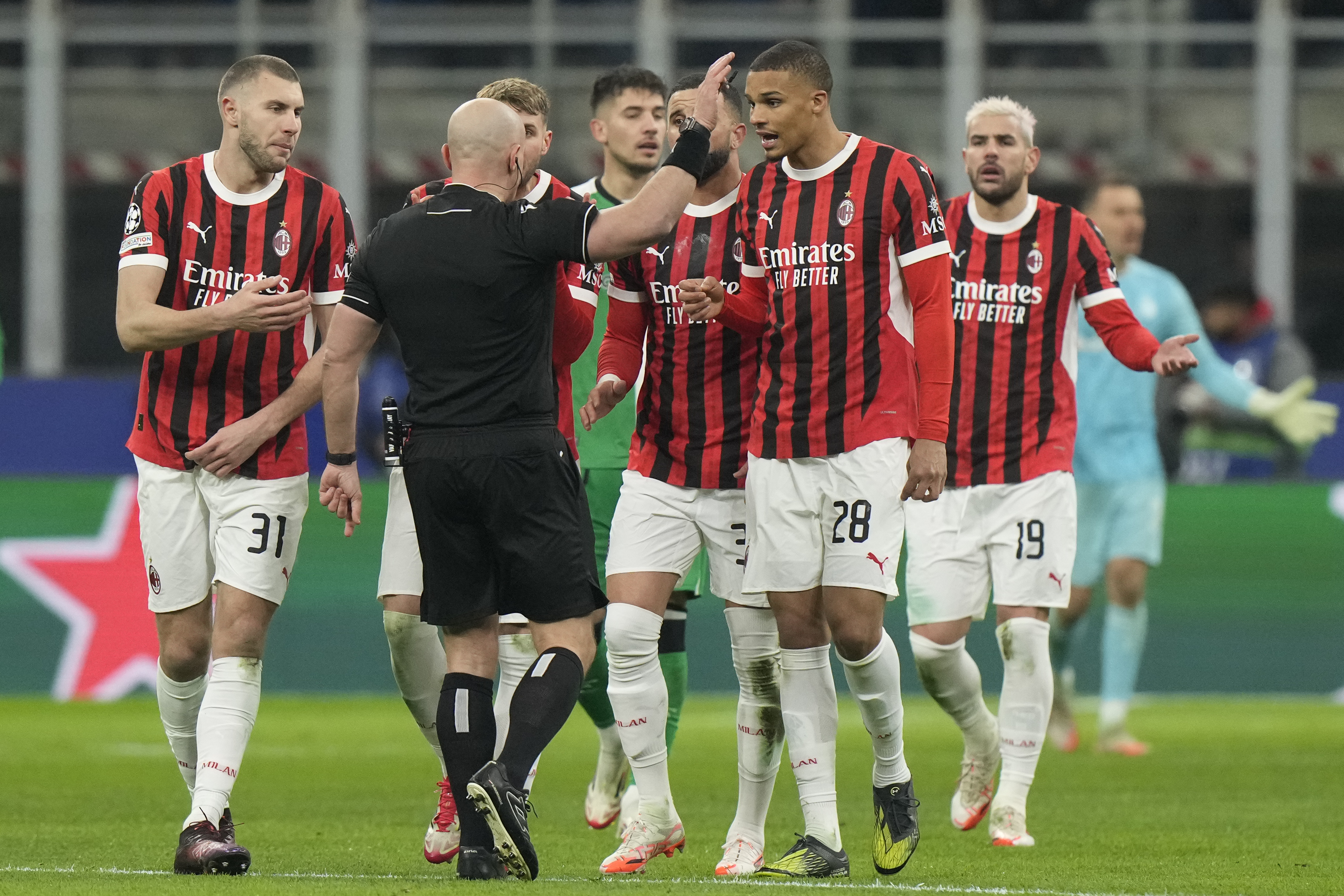AC Milan's players argue with Referee Szymon Marciniak of Poland after he sent off AC Milan's Theo Hernandez, right, during Champions League, playoff second leg soccer match between AC Milan and Feyenoord, at the San Siro stadium in Milan, Italy, Tuesday, Feb.18, 2025.