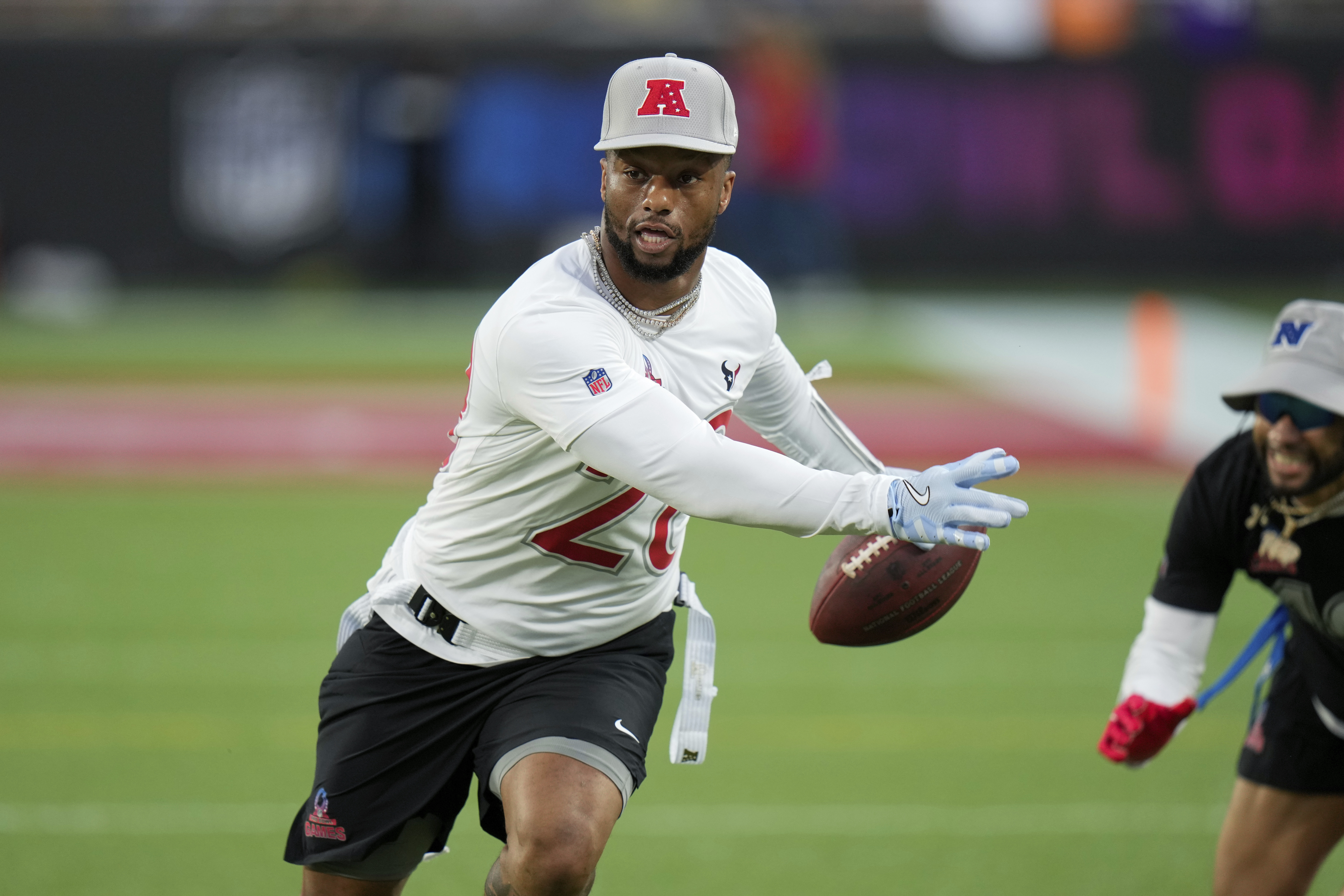 AFC running back Joe Mixon, of the Houston Texans, left, scores a touchdown during the flag football event at the NFL Pro Bowl, Sunday, Feb. 2, 2025, in Orlando.