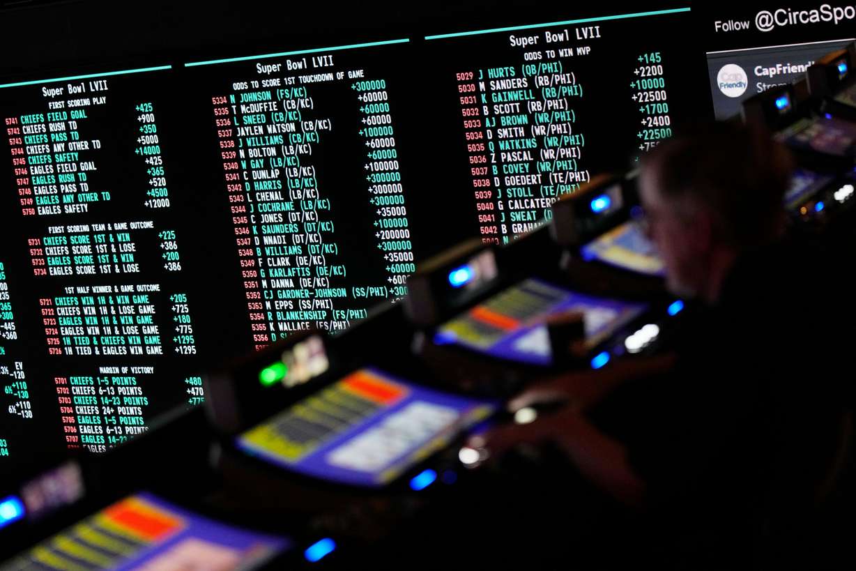 A person gambles as betting odds for NFL football's Super Bowl are displayed on monitors at the Circa resort and casino sports book, Feb. 3, 2023, in Las Vegas.