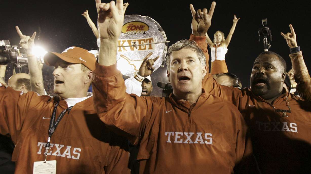 FILE - Texas head coach Mack Brown, center, does the hook'em horns sign with the coaching staff after they beat Southern California in the Rose Bowl, the national championship college football game, Jan. 4, 2006, in Pasadena, Calif.