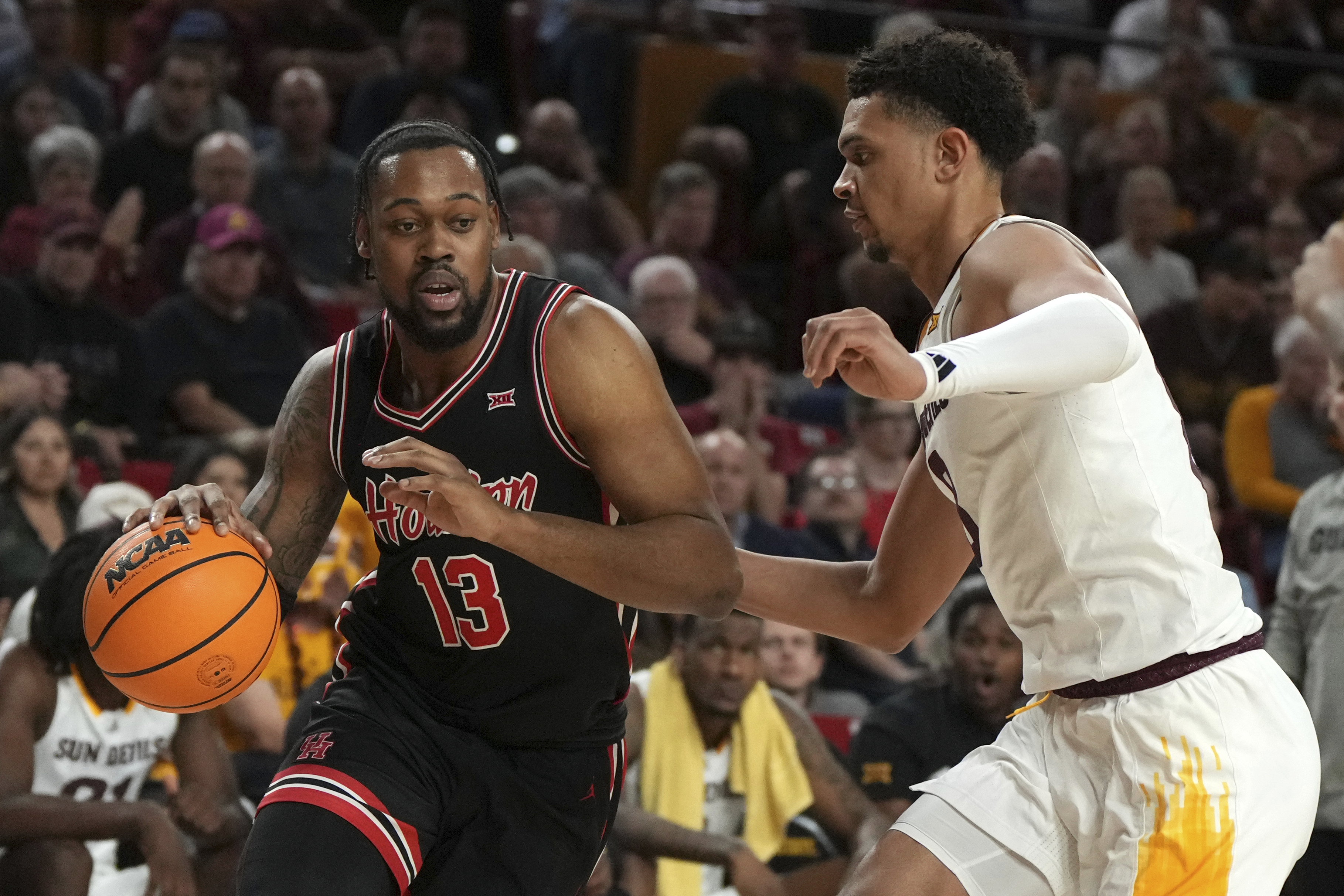 Houston forward J'Wan Roberts (13) drives on Arizona State forward Basheer Jihad during the first half of an NCAA college basketball game, Tuesday, Feb. 18, 2025, in Tempe, Ariz.