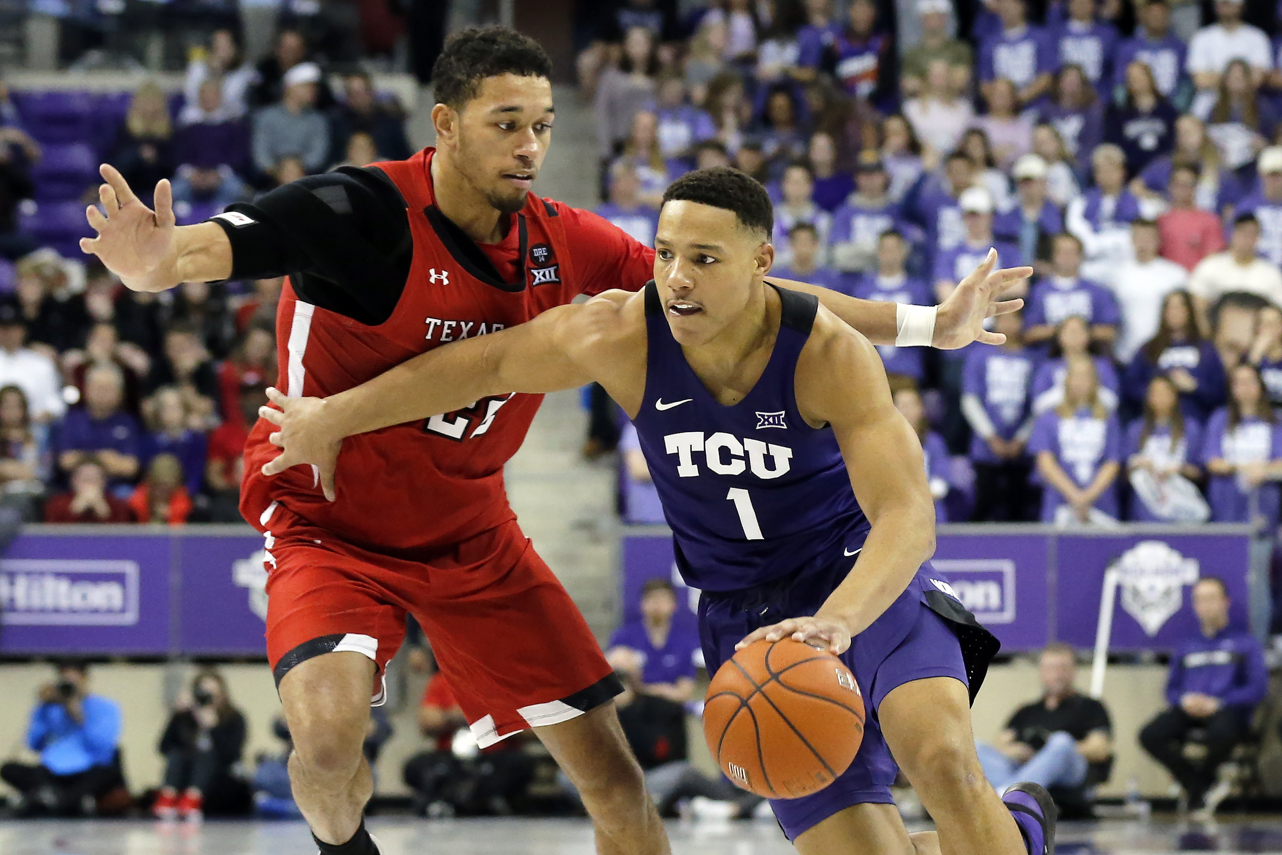 FILE - TCU guard Desmond Bane (1) drives to the basket as Texas Tech forward TJ Holyfield defends during the second half of an NCAA college basketball game in Fort Worth, Texas, Jan. 21, 2020.