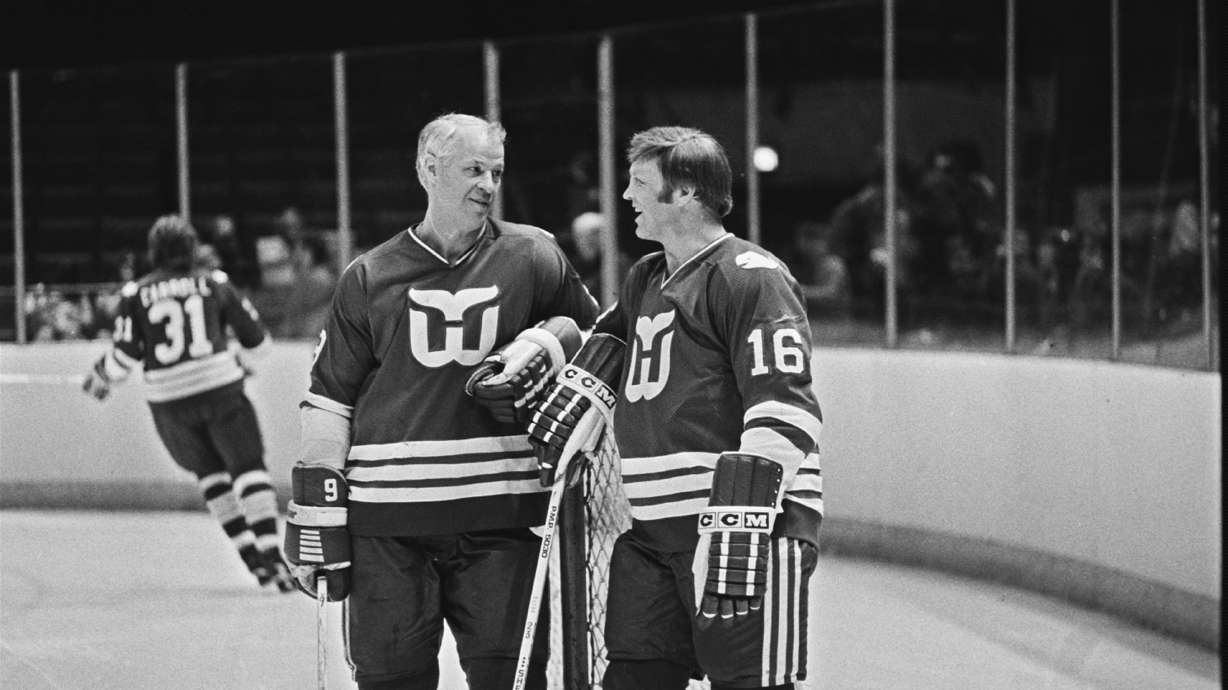 FILE - Hartford Whalers' star Gordie Howe, left, and Bobby Hull, right, have a chat as Hartford Whalers practice before their NHL game with the Washington Capitals, March 8, 1980.
