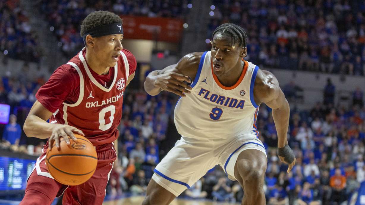 Oklahoma guard Jeremiah Fears (0) drives on Florida center Rueben Chinyelu (9) during the first half of an NCAA college basketball game, Tuesday, Feb. 18, 2025, in Gainesville, Fla.