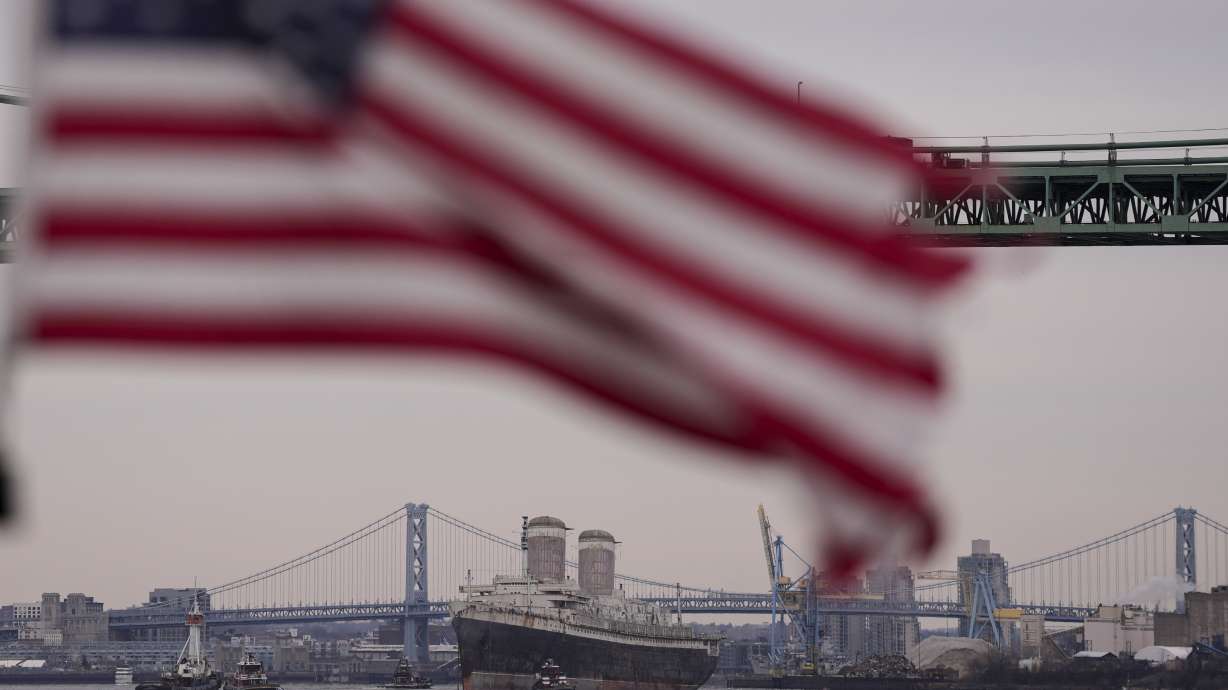 The SS United States is towed down the Delaware River between Pennsylvania and New Jersey, from Philadelphia, Wednesday.