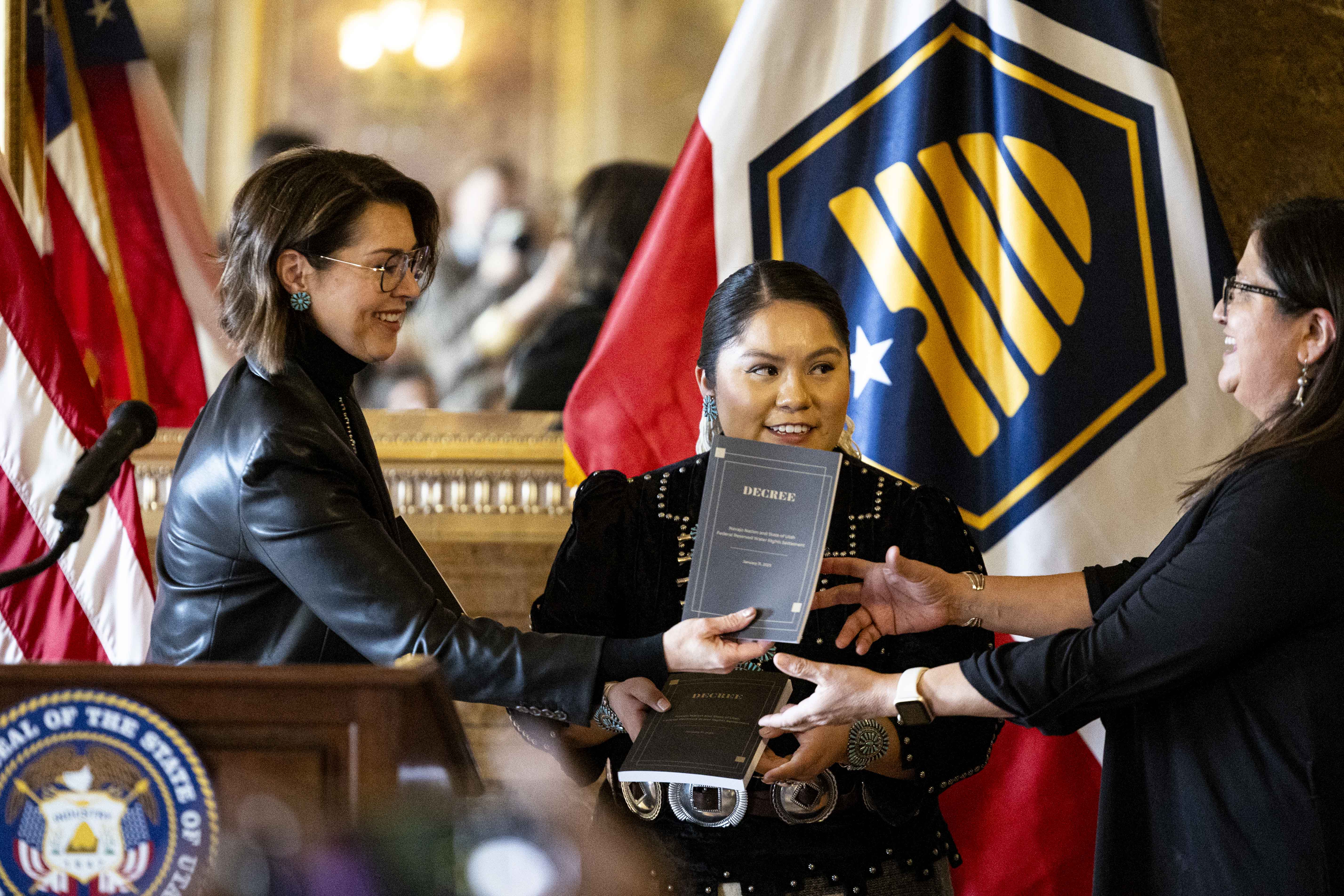 Utah Lt. Gov. Deidre Henderson passes a decree to Michelle Espino, chief legislative counsel of the 25th Navajo Nation Council, as they’re joined by Shaandiin Parrish, chair of the Budget and Finance Committee of the 25th Navajo Nation Council, during a press conference celebrating the state of Utah and the Navajo Nation finalizing a landmark water rights agreement held in the Gold Room of the Capitol in Salt Lake City on Wednesday.