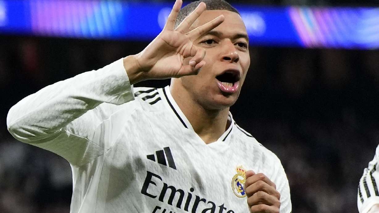 Real Madrid's Kylian Mbappe celebrates with Real Madrid's Jude Bellingham, right, after scoring his sides third goal during the Champions League playoff second leg soccer match between Real Madrid and Manchester City at the Santiago Bernabeu Stadium in Madrid, Spain, Wednesday, Feb. 19, 2025.