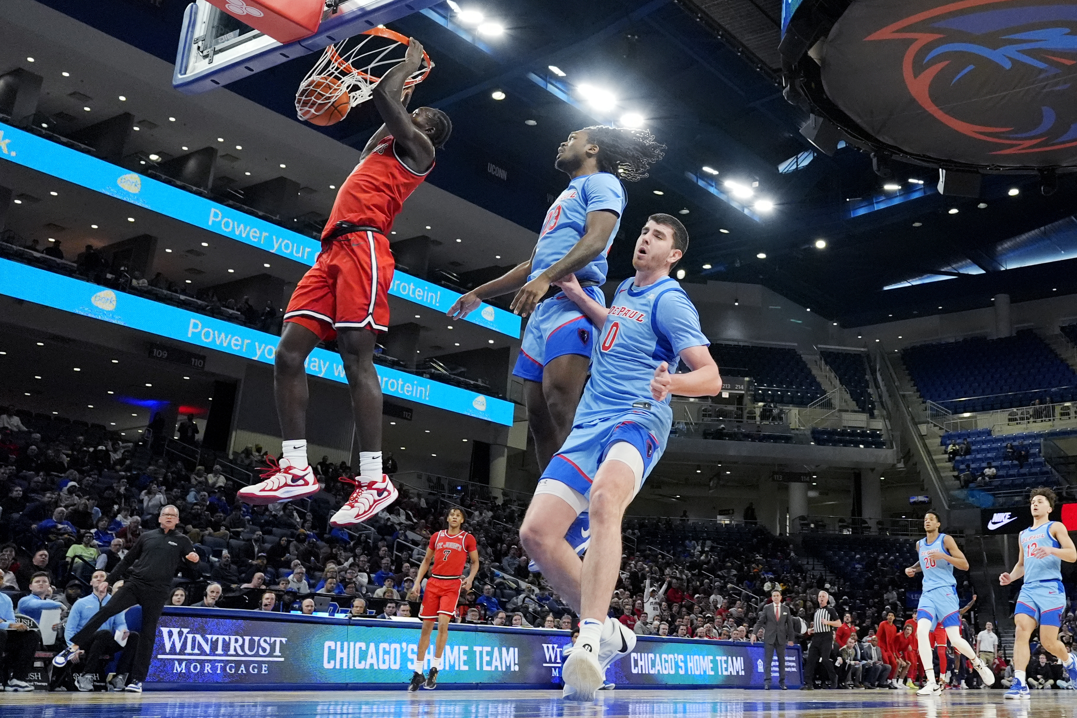 St. John's forward Sadiku Ibine Ayo, left, dunks past DePaul guard David Thomas, center, and forward Troy D'Amico during the first half of an NCAA college basketball game in Chicago, Wednesday, Feb. 19, 2025. 