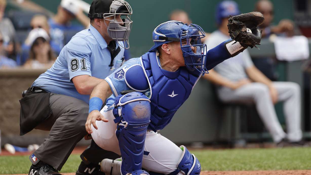 FILE - Kansas City Royals catcher Freddy Fermin (34) takes a pitch as home plate umpire Quinn Wolcott (81) calls the balls and strikes during a baseball game against the Chicago Cubs in Kansas City, Mo., Sunday, July 28, 2024.