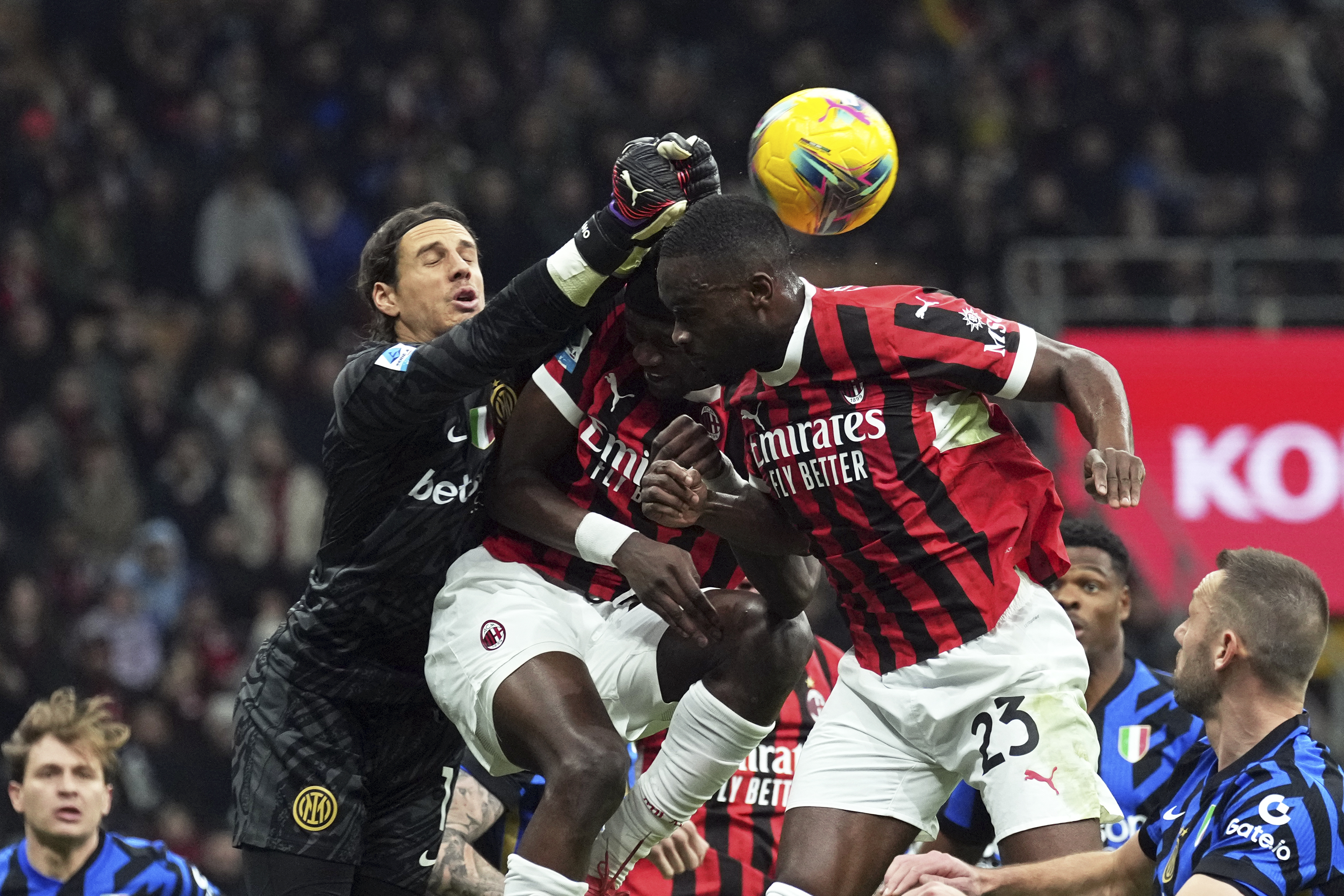 Inter Milan's goalkeeper Yann Sommer punches the ball away from AC Milan's Tammy Abraham and Fikayo Tomori, top right, during the Serie A soccer match between AC Milan and Inter Milan at the San Siro stadium, in Milan, Italy, Sunday, Feb. 2, 2025.