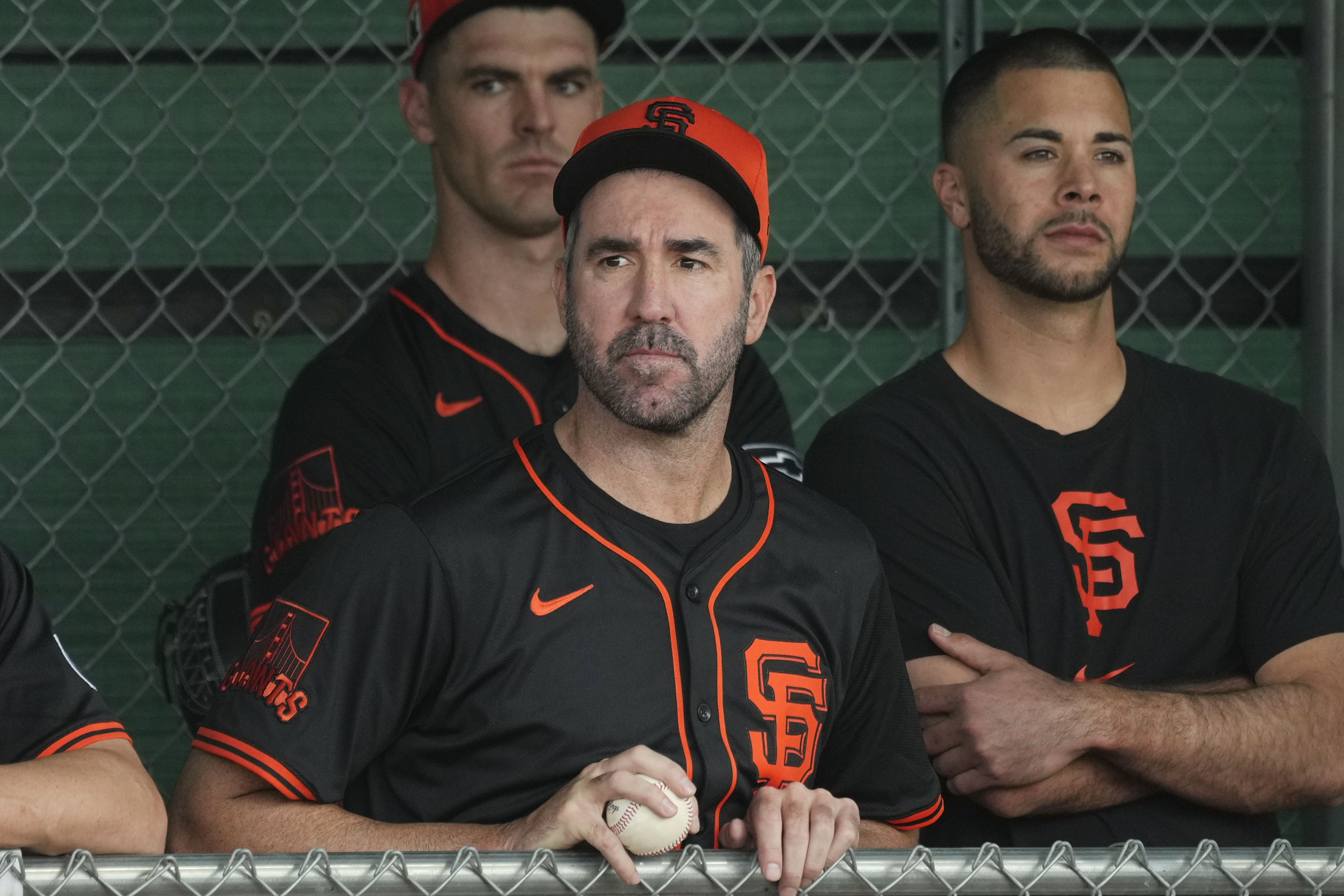 San Francisco Giants pitchers Justin Verlander, center, Joey Lucchesi, right, and Carson Ragsdale watches other pitchers throw at the team's spring training baseball facility Thursday, Feb. 13, 2025, in Scottsdale, Ariz. 
