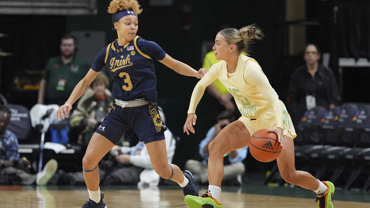 Miami guard Hanna Cavinder (15) drives forward, defended by Notre Dame guard Hannah Hidalgo (3), in the first half of an NCAA college basketball game, Thursday, Feb. 20, 2025, in Coral Gables, Fla.