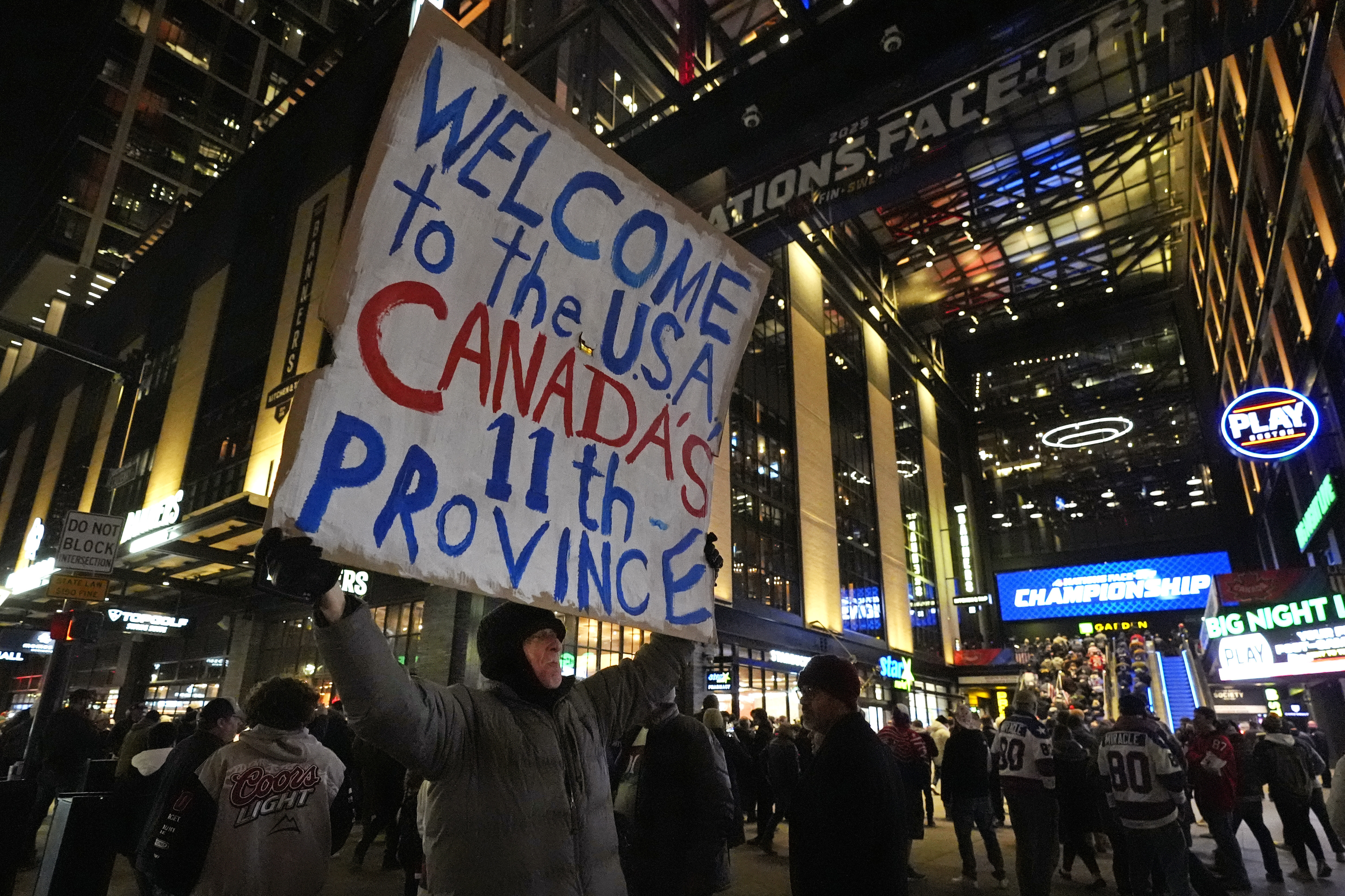 As fans enter the Boston Garden, a man holds a sign on the sidewalk prior to the 4 Nations Face-Off championship hockey game between the United States and Canada, Thursday, Feb. 20, 2025, in Boston. 
