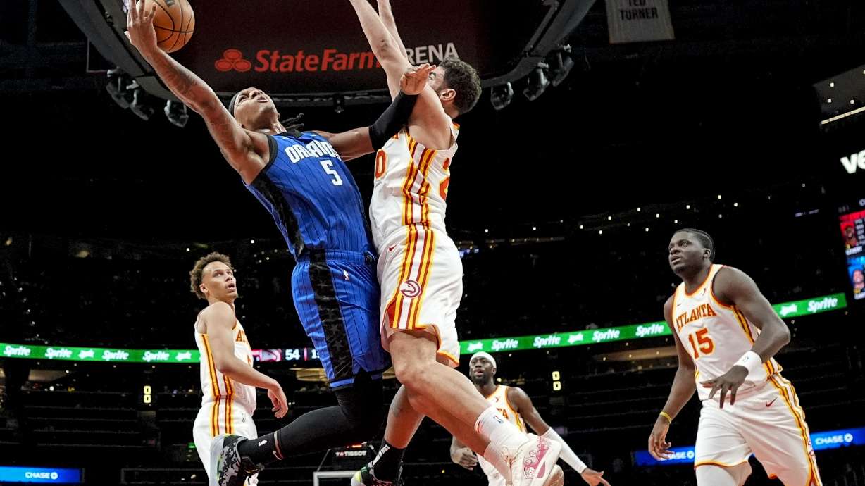 Orlando Magic forward Paolo Banchero (5) shoots against Atlanta Hawks forward Georges Niang (20) during the first half of an NBA basketball game, Thursday, Feb. 20, 2025, in Atlanta.