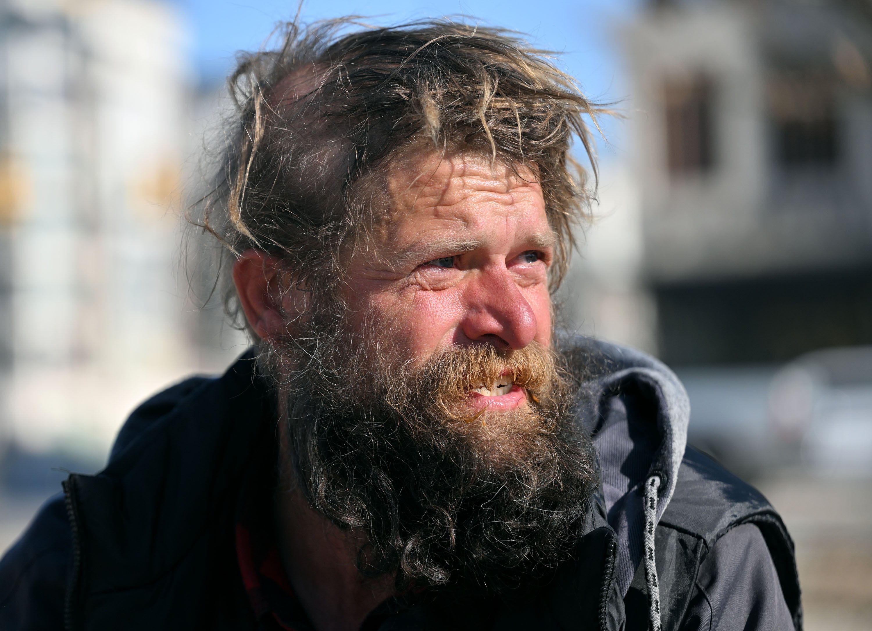 Leslie Young, a man experiencing homelessness, looks around at others like himself as he sits on the ground near the Salt Lake City Police Department and library in Salt Lake City on Jan. 28.