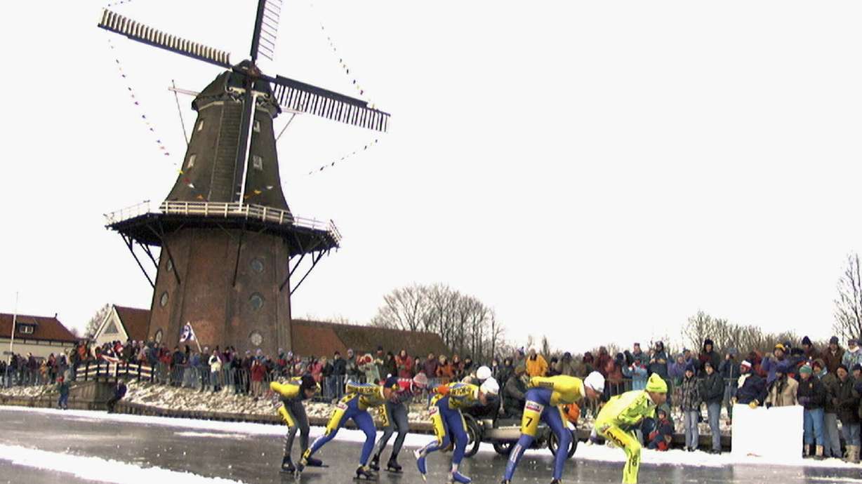 FILE - Skaters pass a windmill at the village of Birdaard, northern Netherlands during the "Elfstedentocht" (eleven-cities-course) race on Jan. 4, 1997.