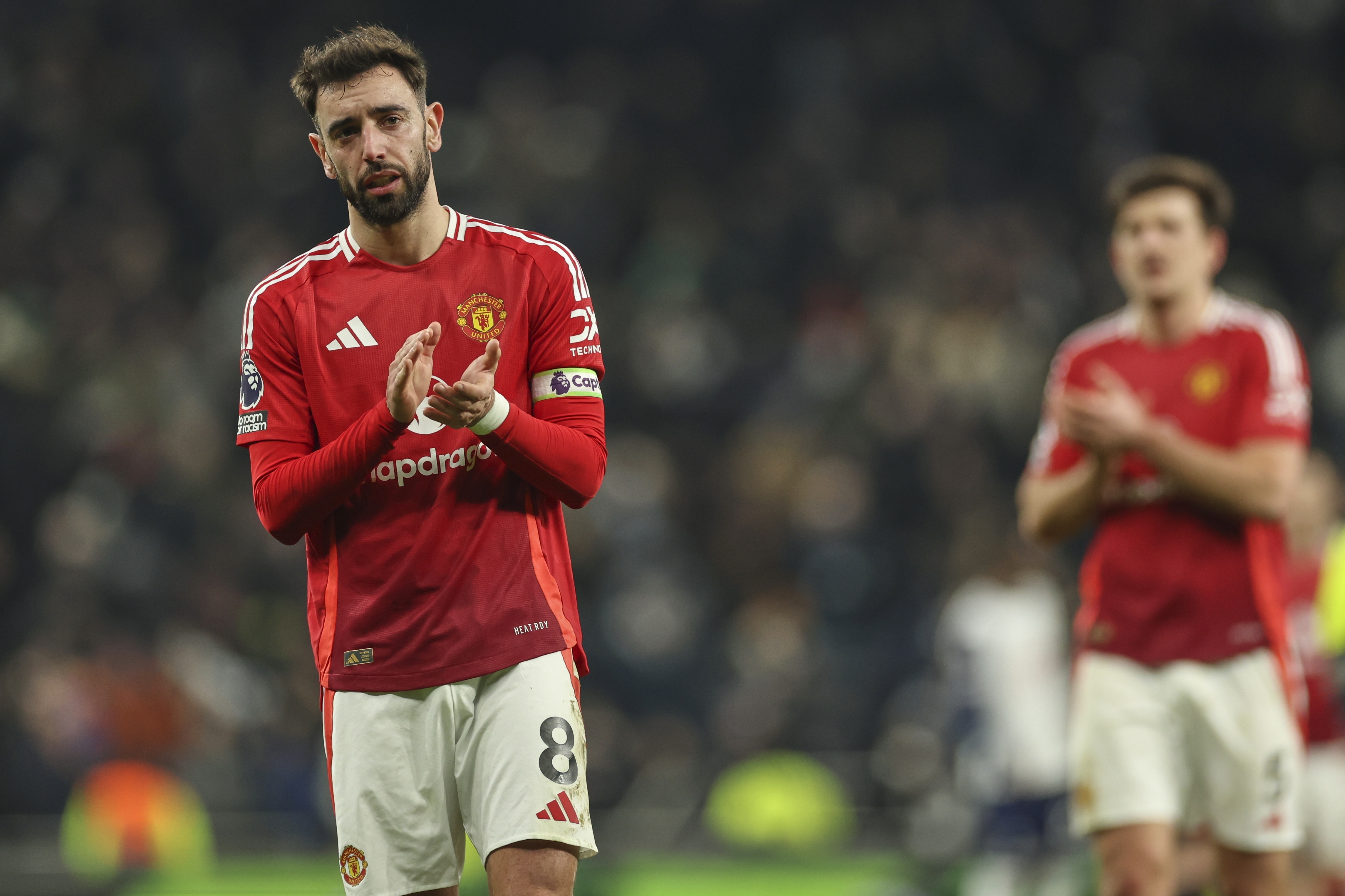 Manchester United's Bruno Fernandes applauds the crowd after the English Premier League soccer match between Tottenham Hotspur and Manchester United in London, Sunday, Feb. 16, 2025. 