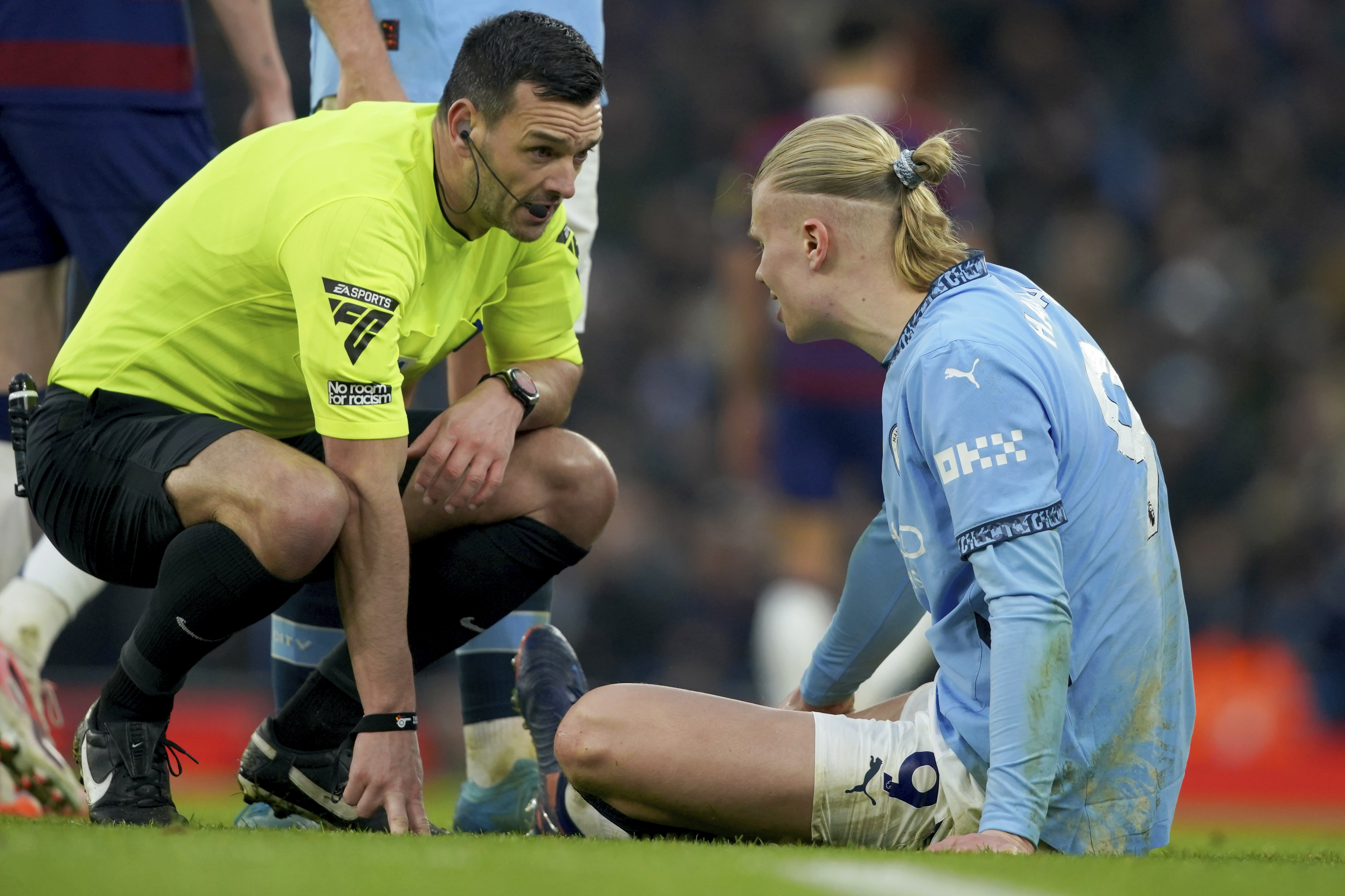 Referee Andy Madley checks on Manchester City's Erling Haaland after he injured himself during the English Premier League soccer match between Manchester City and Newcastle United at Etihad stadium in Manchester, England, Saturday, Feb. 15, 2025. 