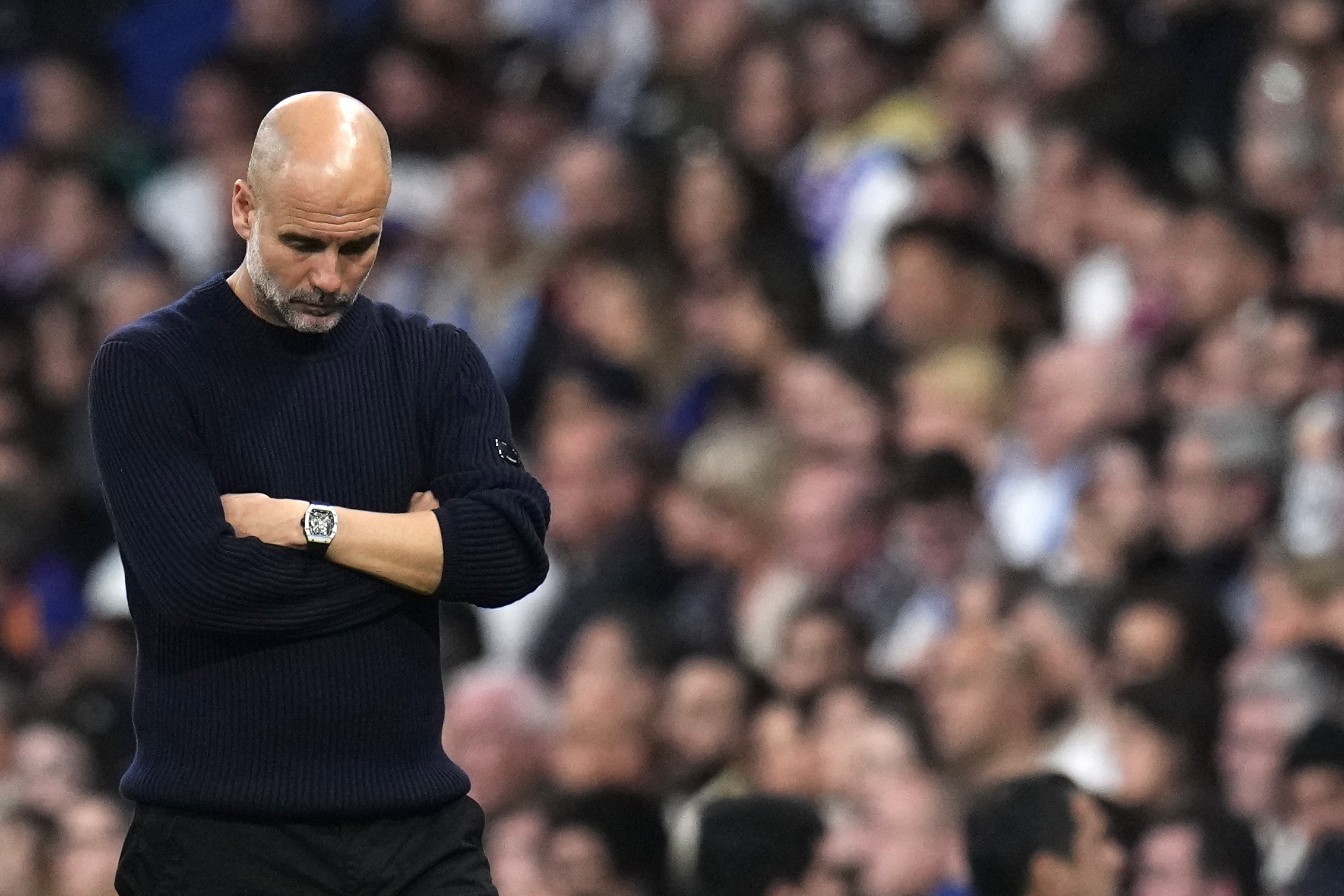 Manchester City's head coach Pep Guardiola grimaces during the Champions League playoff second leg soccer match between Real Madrid and Manchester City at the Santiago Bernabeu Stadium in Madrid, Spain, Wednesday, Feb. 19, 2025. 