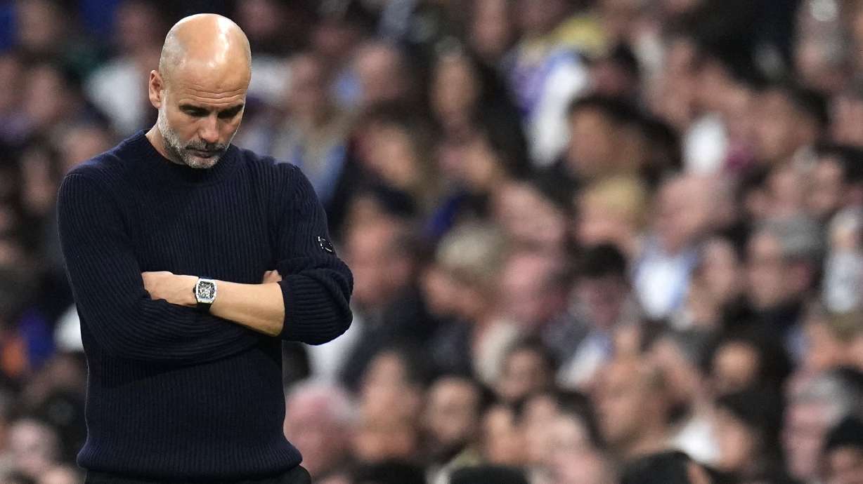 Manchester City's head coach Pep Guardiola grimaces during the Champions League playoff second leg soccer match between Real Madrid and Manchester City at the Santiago Bernabeu Stadium in Madrid, Spain, Wednesday, Feb. 19, 2025.