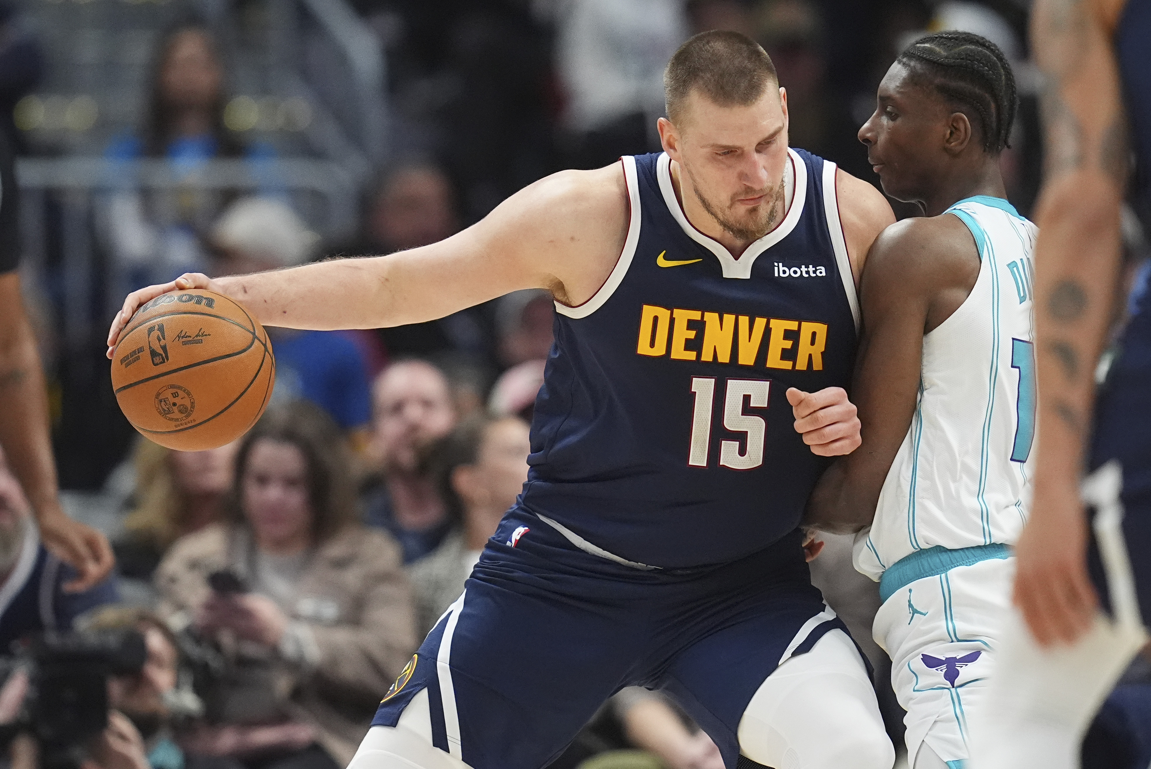 Denver Nuggets center Nikola Jokic, left, drives to the basket as Charlotte Hornets forward Moussa Diabate defends in the second half of an NBA basketball game Thursday, Feb. 20, 2025, in Denver. 