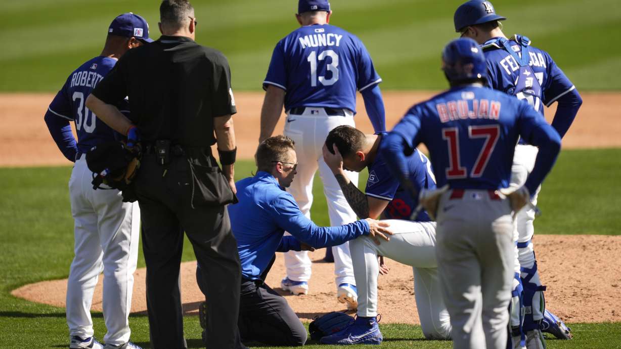 Los Angeles Dodgers pitcher Bobby Miller reacts after being hit by a line drive from Chicago Cubs' Michael Busch during the third inning of a spring training baseball game, Thursday, Feb. 20, 2025, in Phoenix.