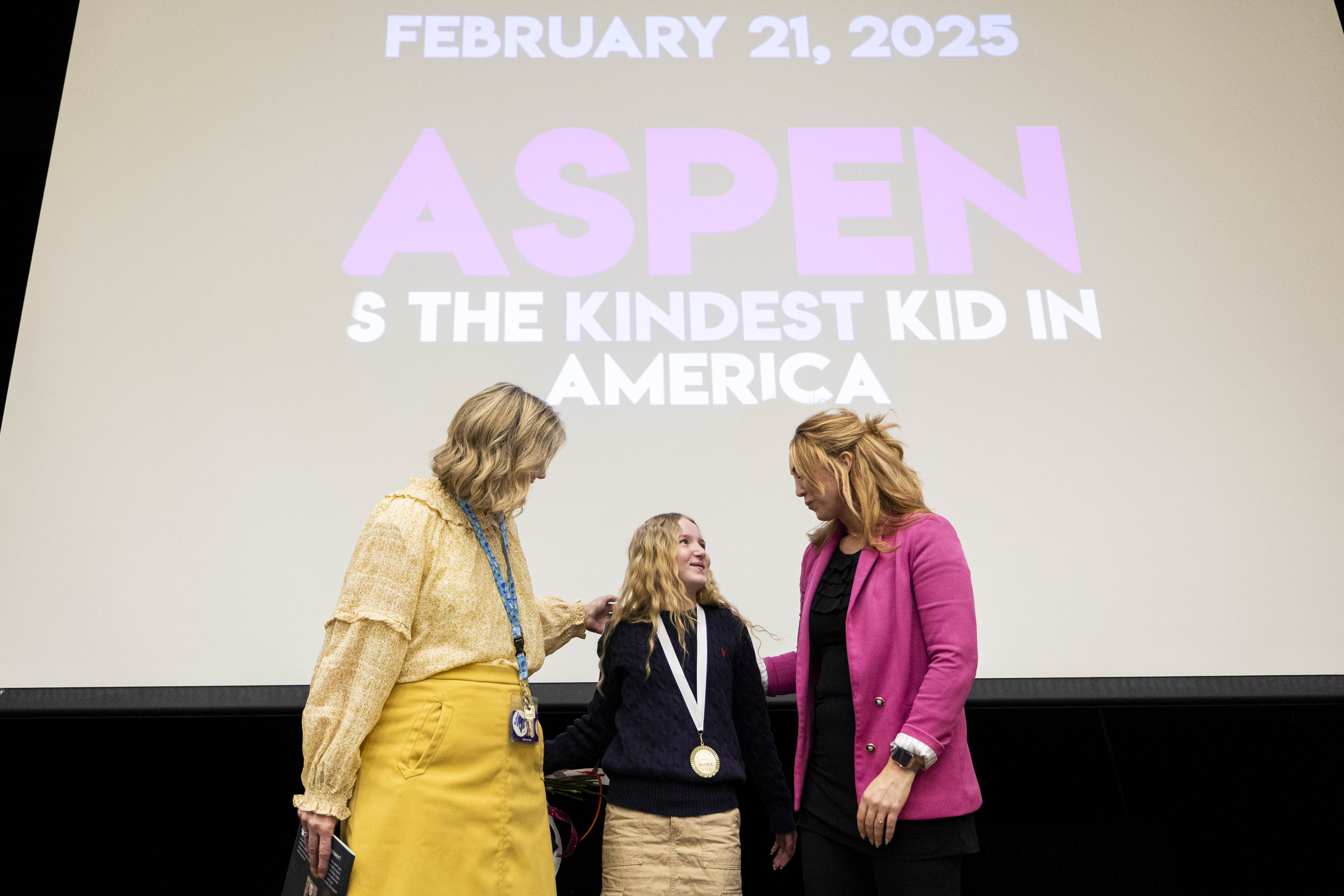 Sixth-grader Aspen Rowley, 12, talks with Jessie Hansen, director of Kindest Kid in America, right, and principal Terri Rigby after posing for photos after an assembly presenting the "Kindest Kid in America" award to Rowley at Sage Hills Elementary School in Saratoga Springs on Friday.