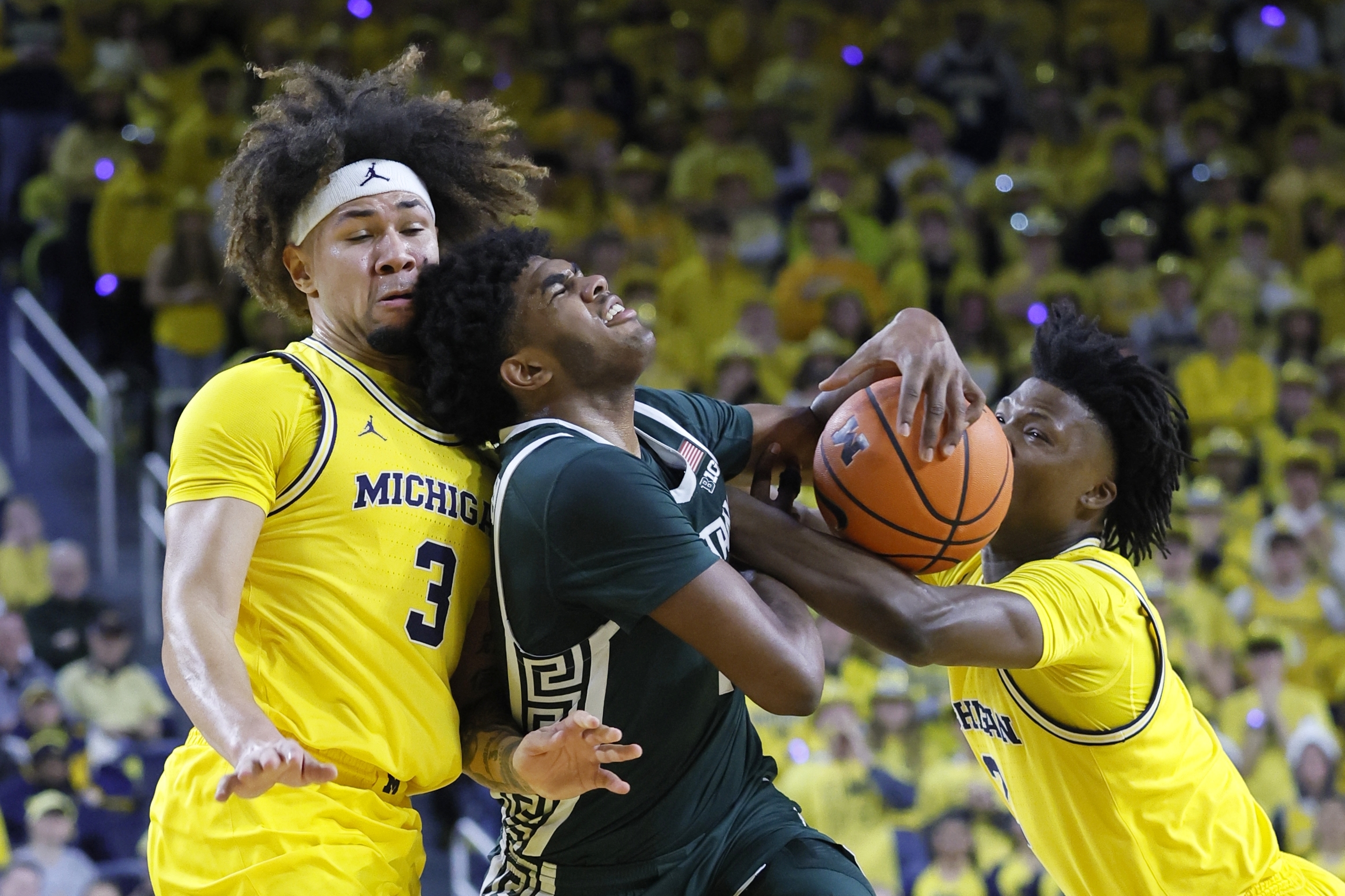 Michigan State guard Jase Richardson, center, is fouled by Michigan guard L.J. Cason, right, while also going to the basket against guard Tre Donaldson (3) during the first half of an NCAA college basketball game Friday, Feb. 21, 2025, in Ann Arbor, Mich. 