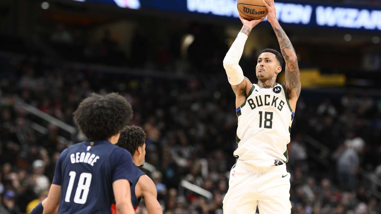 Milwaukee Bucks forward Kyle Kuzma, right, looks to shoot against Washington Wizards forward Kyshawn George, left, during the second half of an NBA basketball game, Friday, Feb. 21, 2025, in Washington.