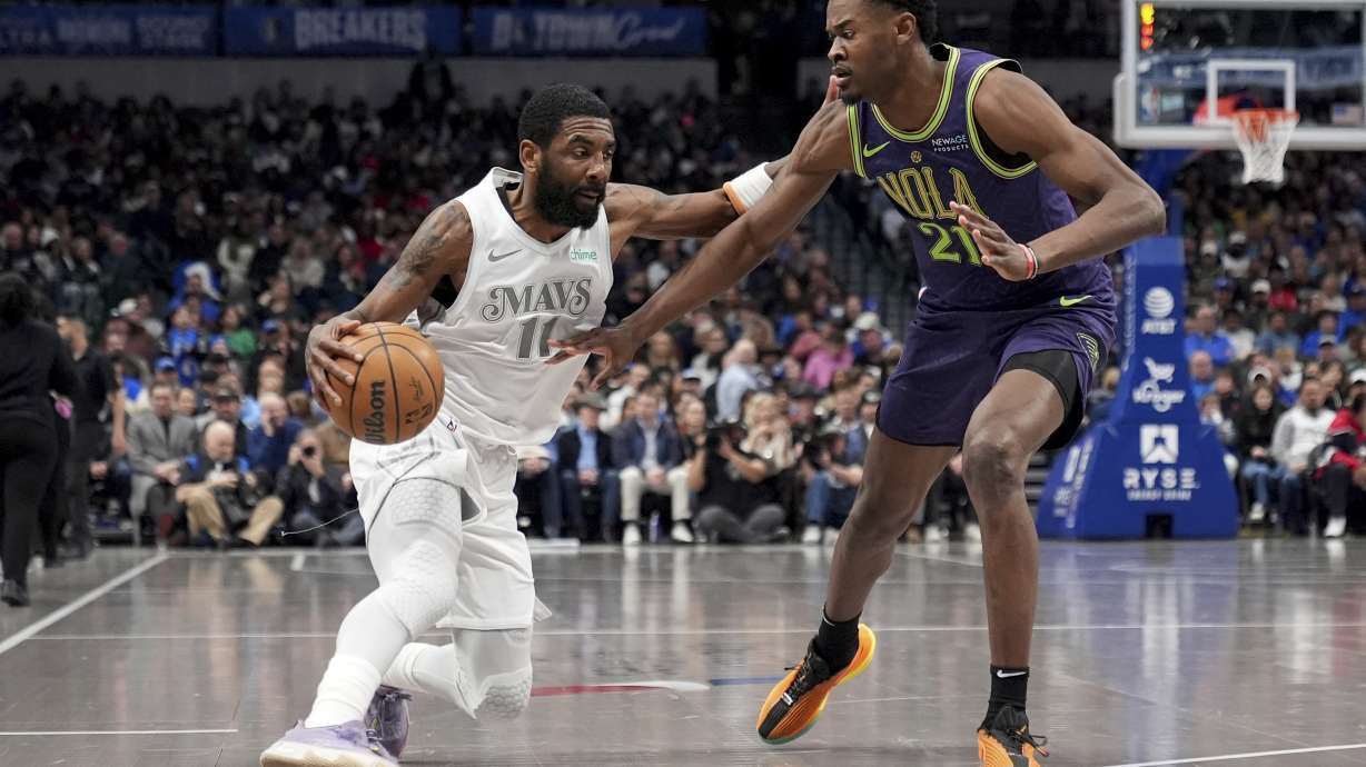 Dallas Mavericks guard Kyrie Irving, left, works against New Orleans Pelicans center Yves Missi (21) in the first half of an NBA basketball game in Dallas, Friday, Feb. 21, 2025.