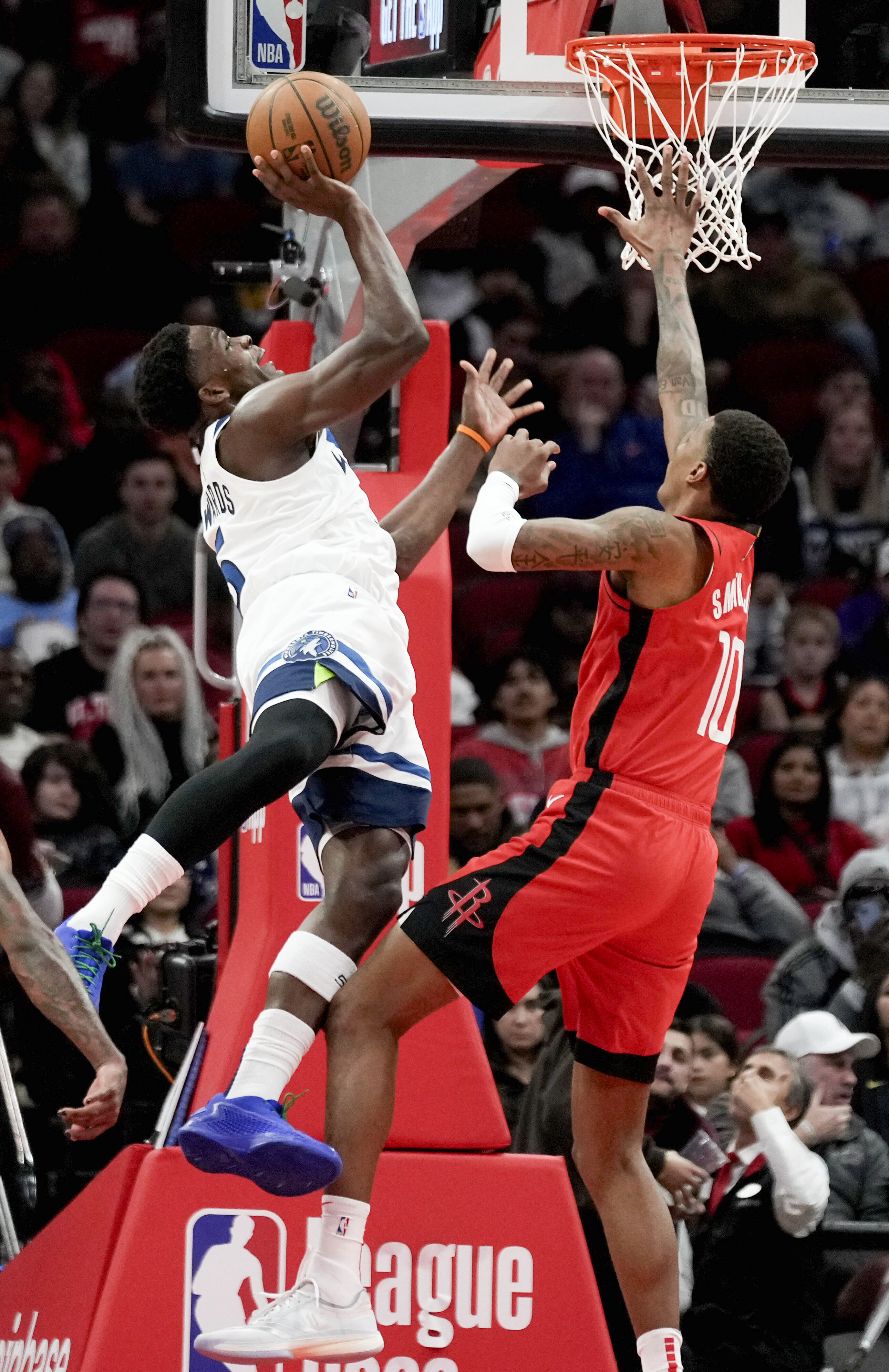 Minnesota Timberwolves guard Anthony Edwards, left, drives to the basket as Houston Rockets forward Jabari Smith Jr. defends during the first half of an NBA basketball game Friday, Feb. 21, 2025, in Houston. 