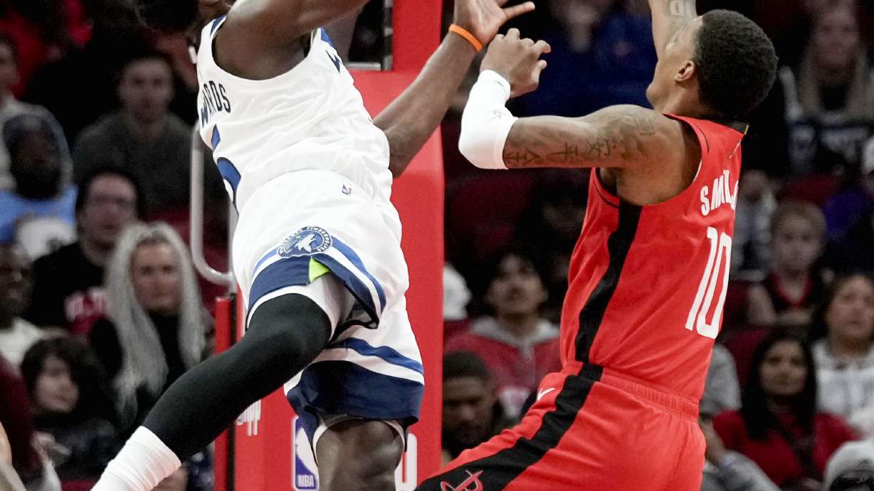 Minnesota Timberwolves guard Anthony Edwards, left, drives to the basket as Houston Rockets forward Jabari Smith Jr. defends during the first half of an NBA basketball game Friday, Feb. 21, 2025, in Houston.