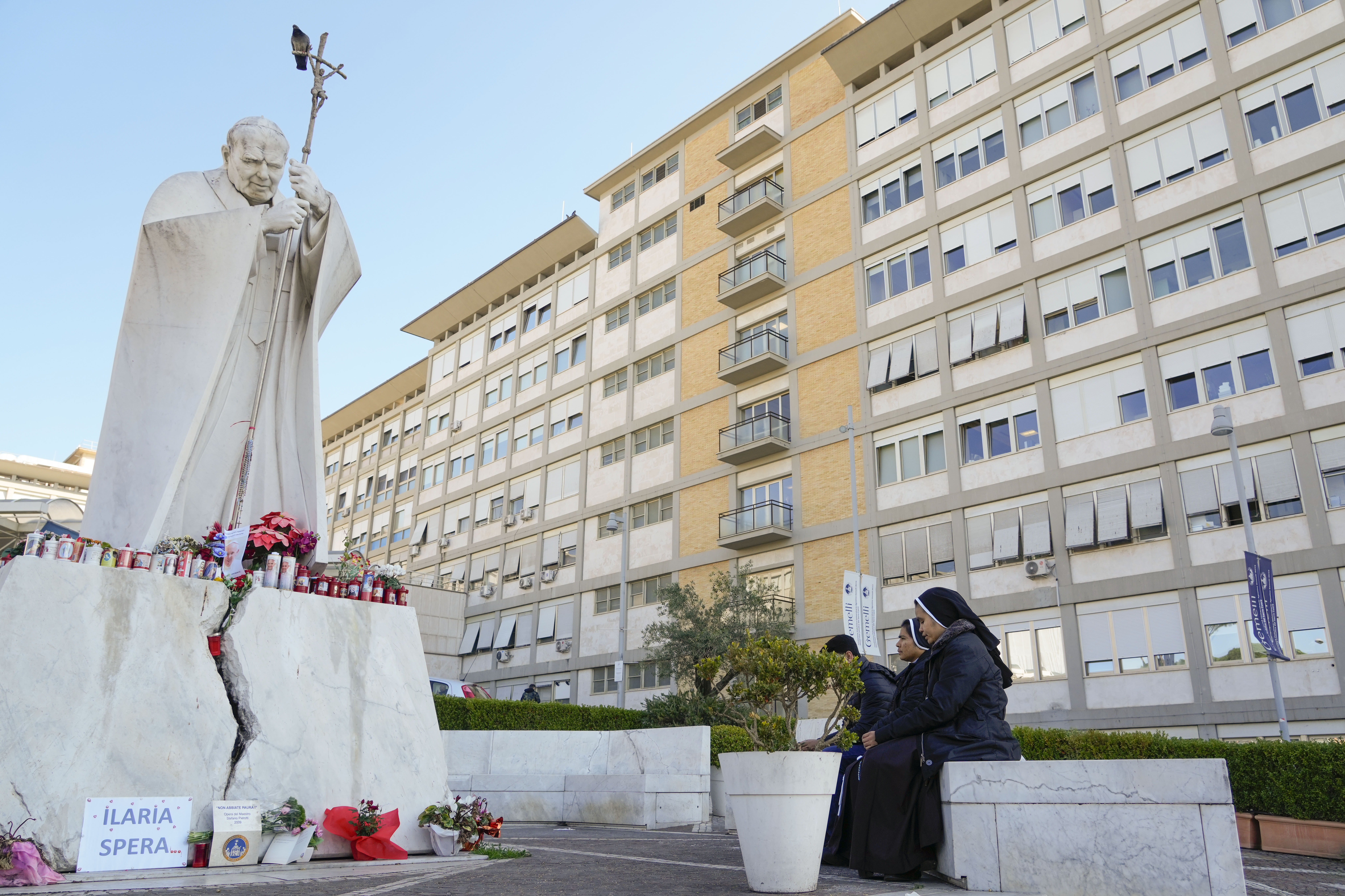 Nuns pray in front of the statue of late Pope John II outside the Agostino Gemelli Polyclinic where Pope Francis is battling pneumonia, in Rome, Saturday.