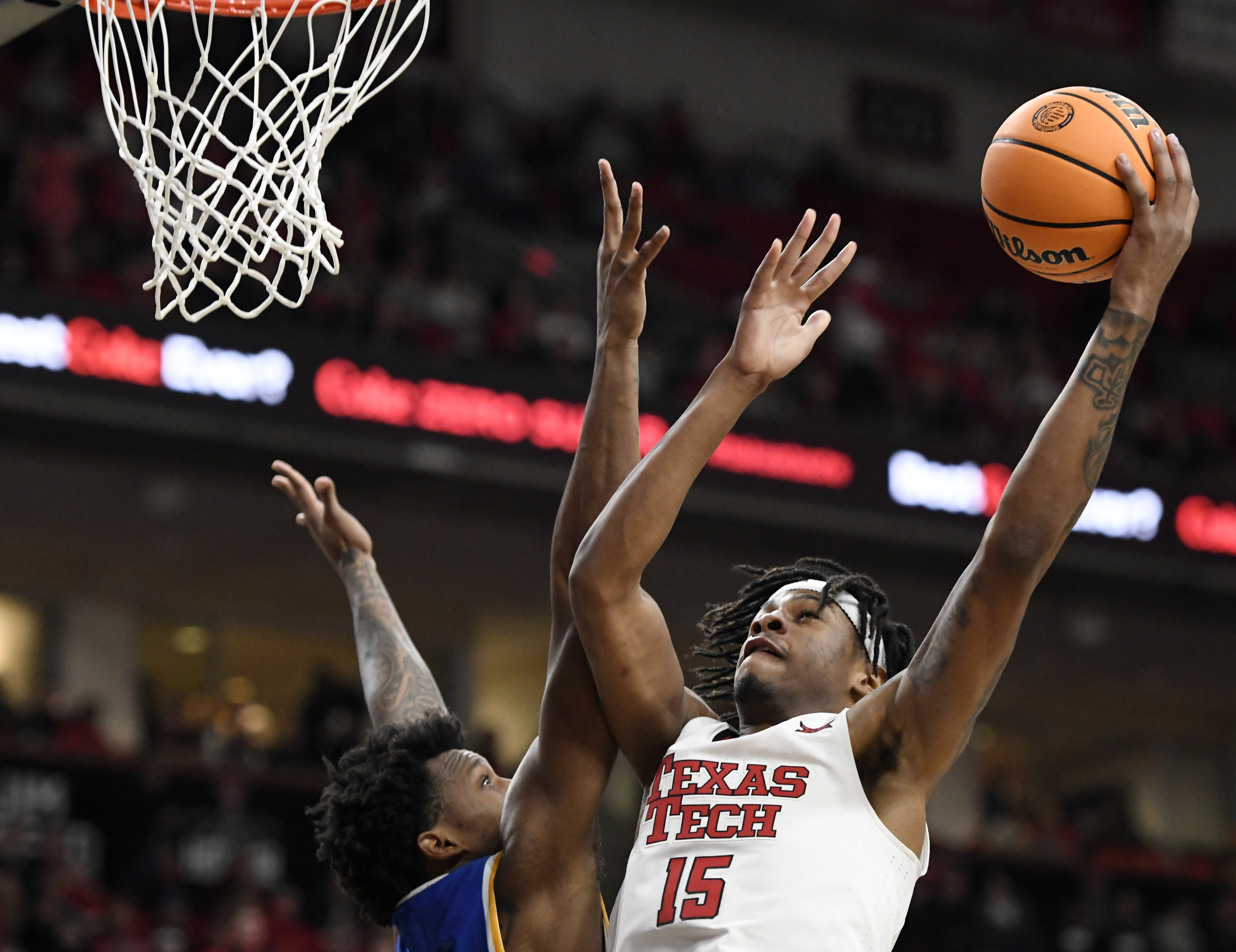 Texas Tech forward JT Toppin (15) goes for a shot as West Virginia forward Amani Hansberry (13) defends during the second half of an NCAA college basketball game, Saturday, Feb. 22, 2025, in Lubbock, Texas. 