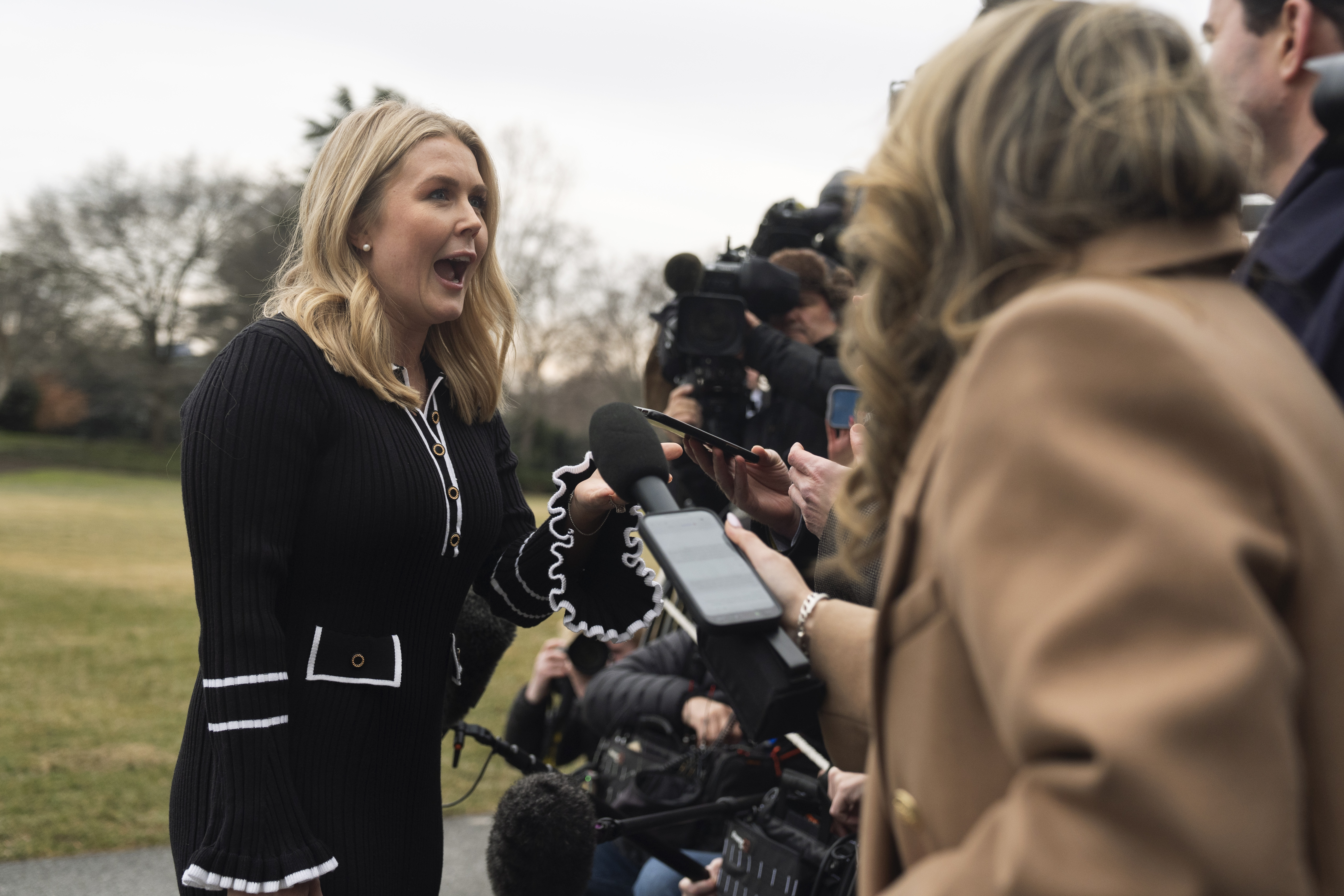 White House press secretary Karoline Leavitt, left, speaks to reporters as she arrives with President Donald Trump on the South Lawn at the White House, Saturday in Washington.