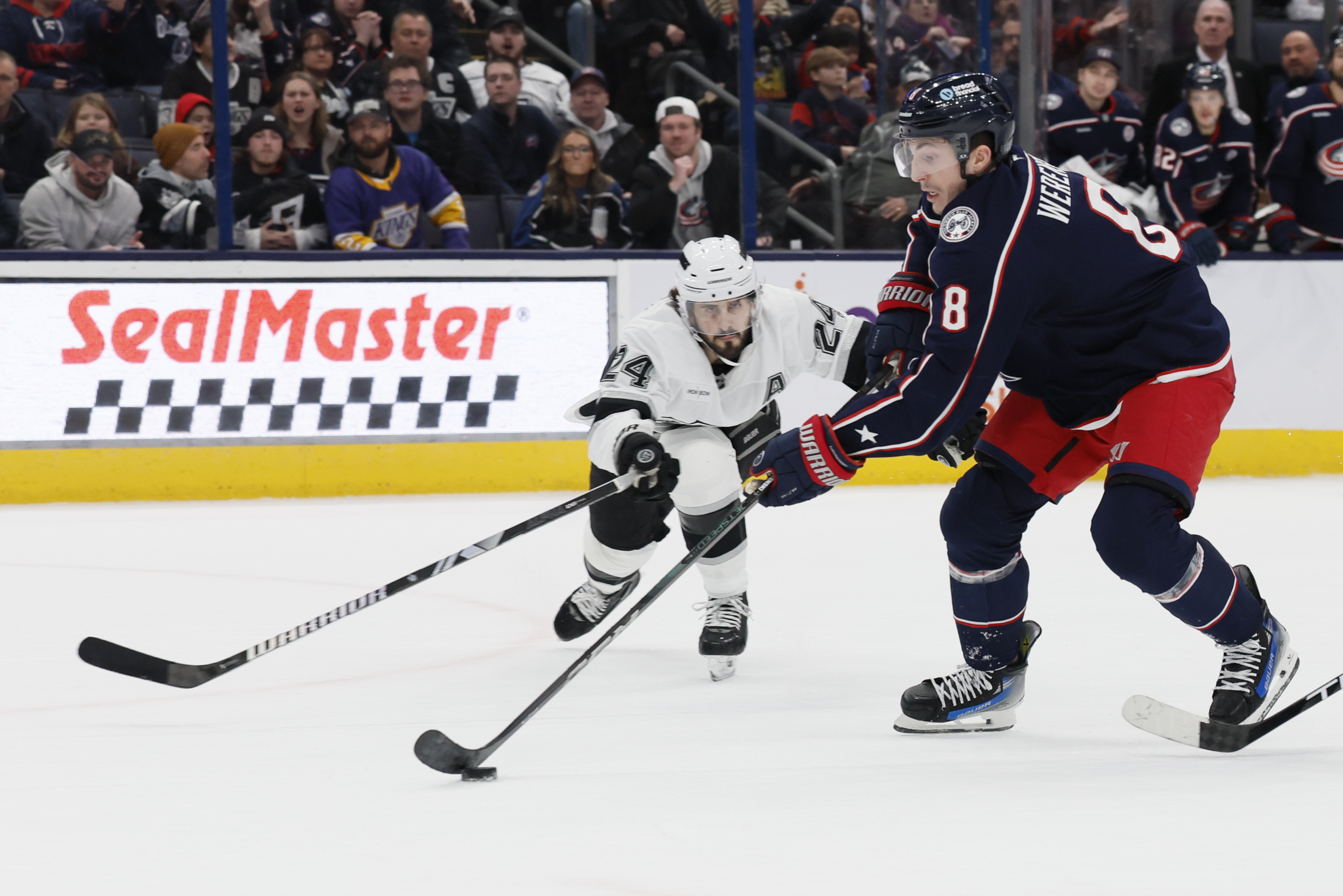 Columbus Blue Jackets' Zach Werenski, right, looks for a shot as Los Angeles Kings' Phillip Danault, left, defends during the overtime period of an NHL hockey game Saturday, Jan. 25, 2025, in Columbus, Ohio. 