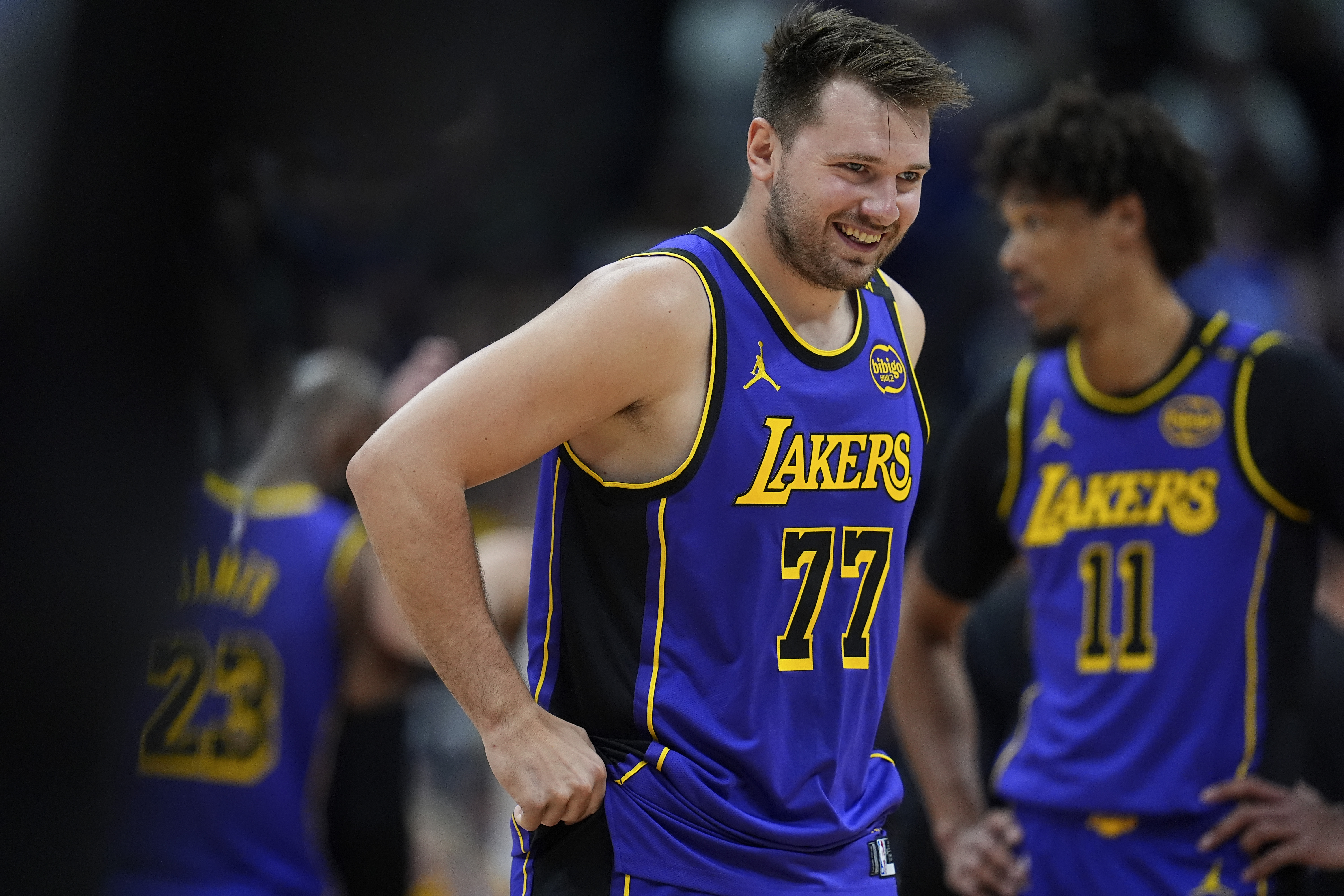 Los Angeles Lakers guard Luka Doncic laughs as he takes the court against the Denver Nuggets in the first half of an NBA basketball game Saturday, Feb. 22, 2025, in Denver. 