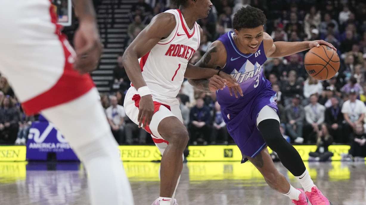 Utah Jazz guard Keyonte George (3) dribbles past Houston Rockets forward Amen Thompson (1) during the first half of an NBA basketball game Saturday, Feb. 22, 2025, in Salt Lake City.