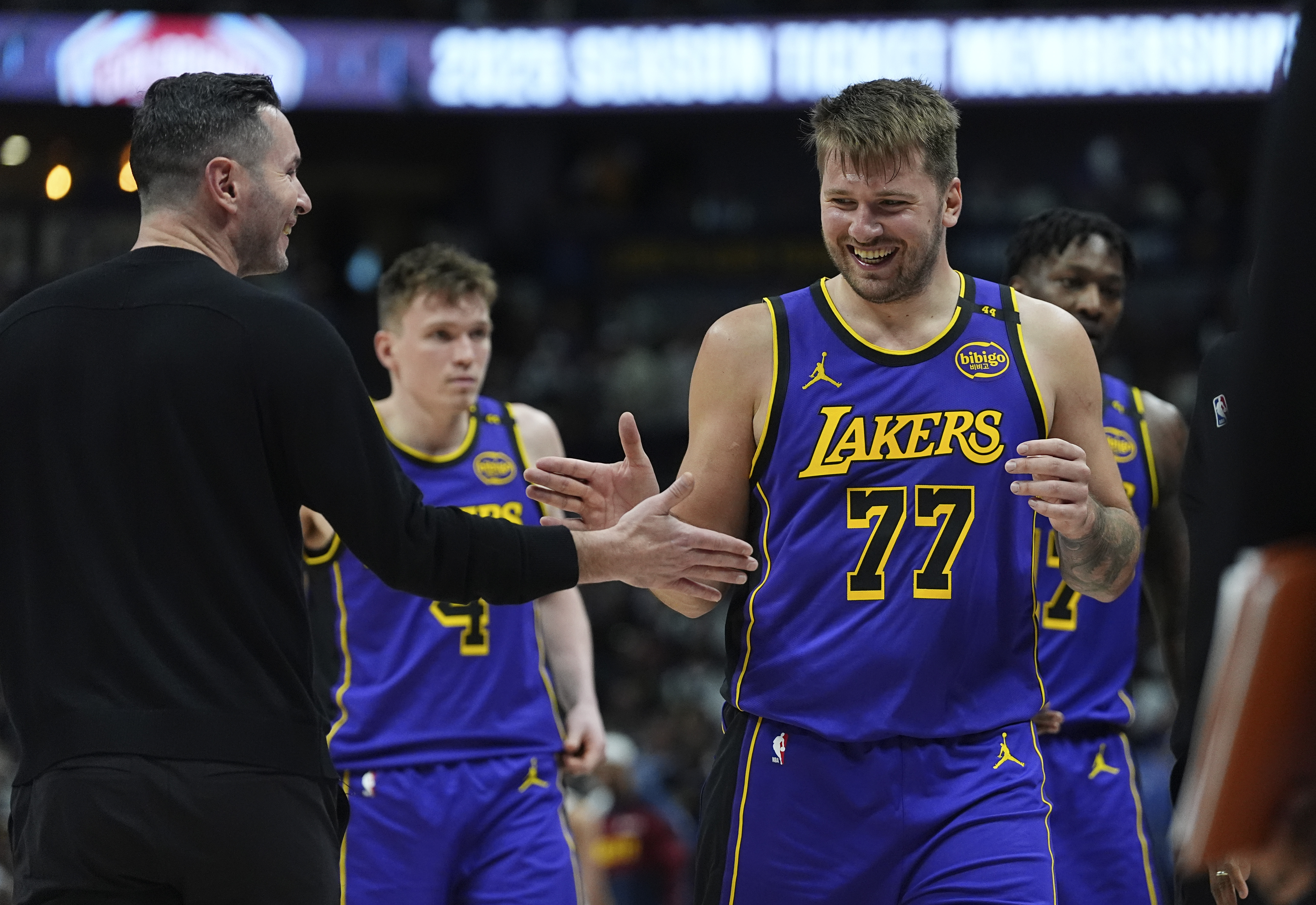 Los Angeles Lakers head coach JJ Redick, left, congratulates guard Luka Doncic as he heads to the bench late in the second half of an NBA basketball game against the Denver Nuggets, Saturday, Feb. 22, 2025, in Denver. 
