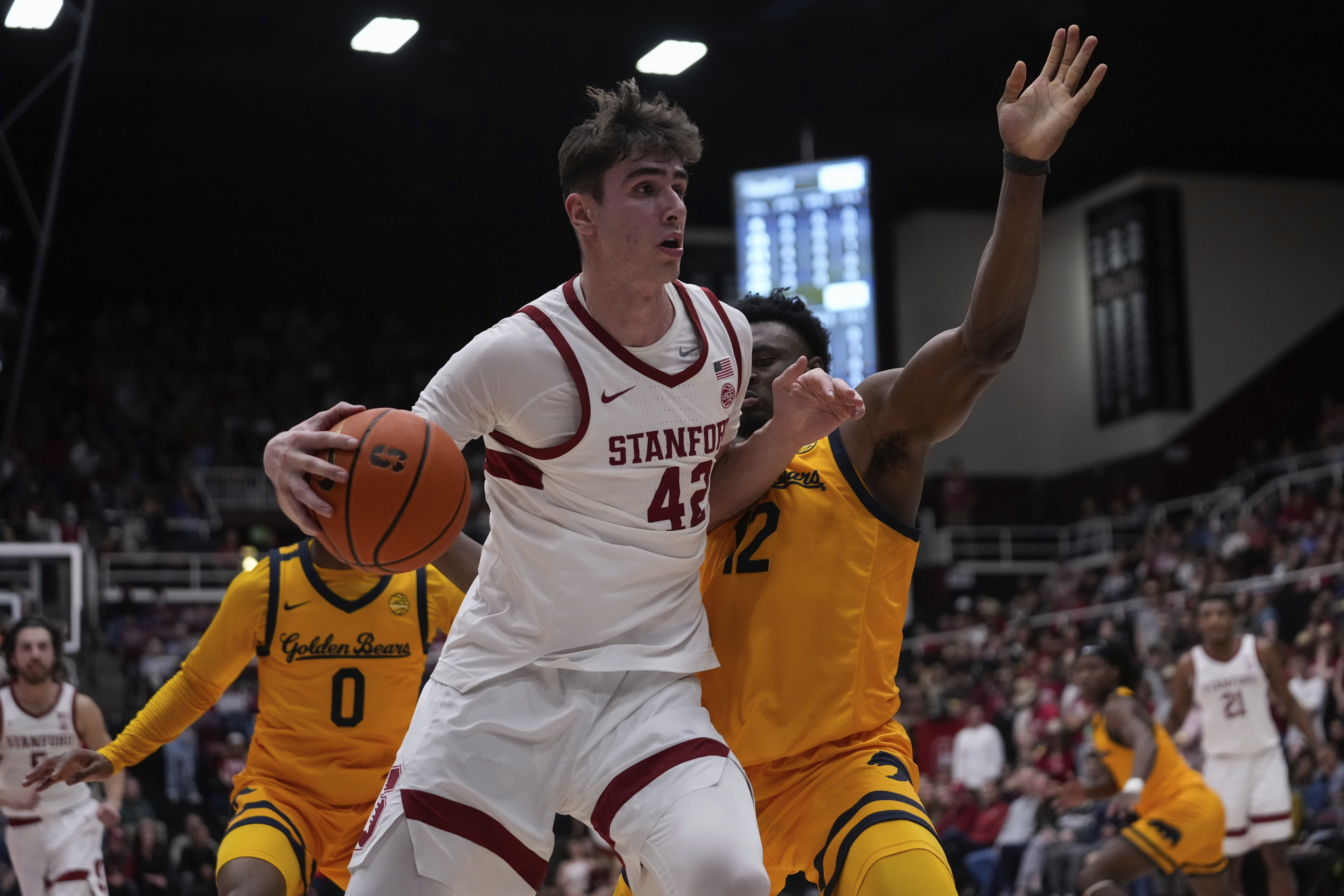 Stanford forward Maxime Raynaud, left, moves the ball while defended by California center Mady Sissoko, right, during the first half of an NCAA college basketball game Saturday, Feb. 22, 2025, in Stanford, Calif. 