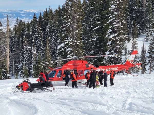 A Life Flight helicopter aids in the rescue of two snowmobilers who got caught in an avalanche in the Snake Creek of Wasatch County on Saturday.