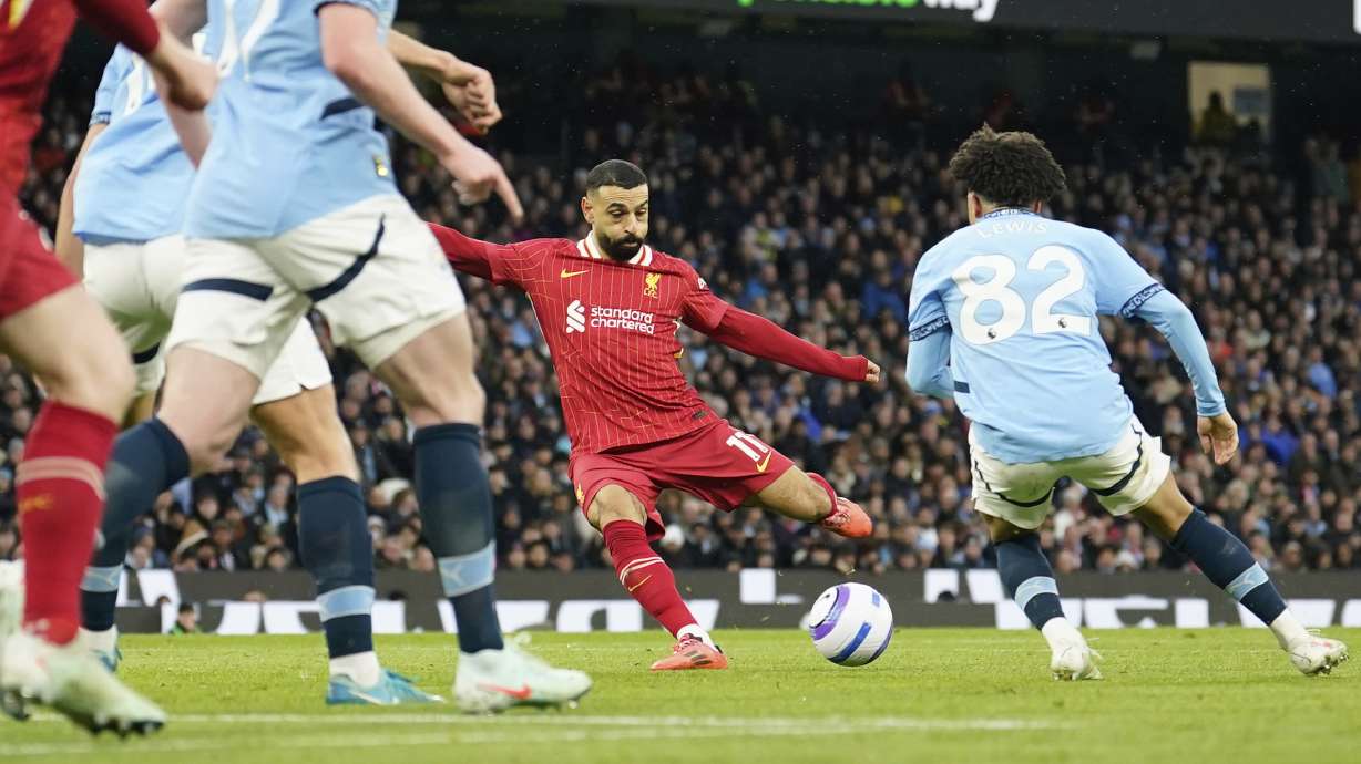 Liverpool's Mohamed Salah, center, scores his side's opening goal during the English Premier League soccer match between Manchester City and Liverpool at Etihad stadium in Manchester, England, Sunday, Feb. 23, 2025.